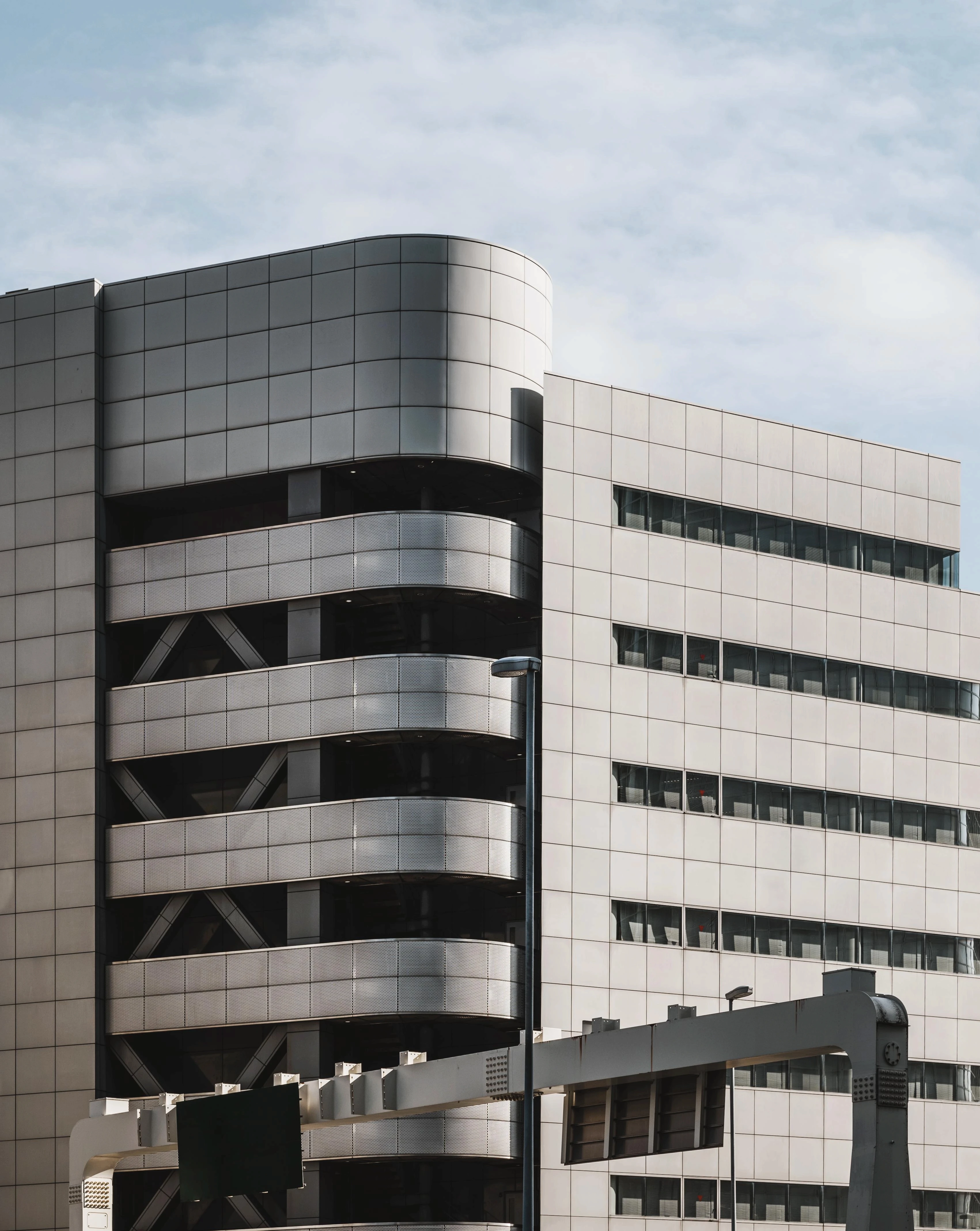 Prédio comercial cinza e um céu com nuvens