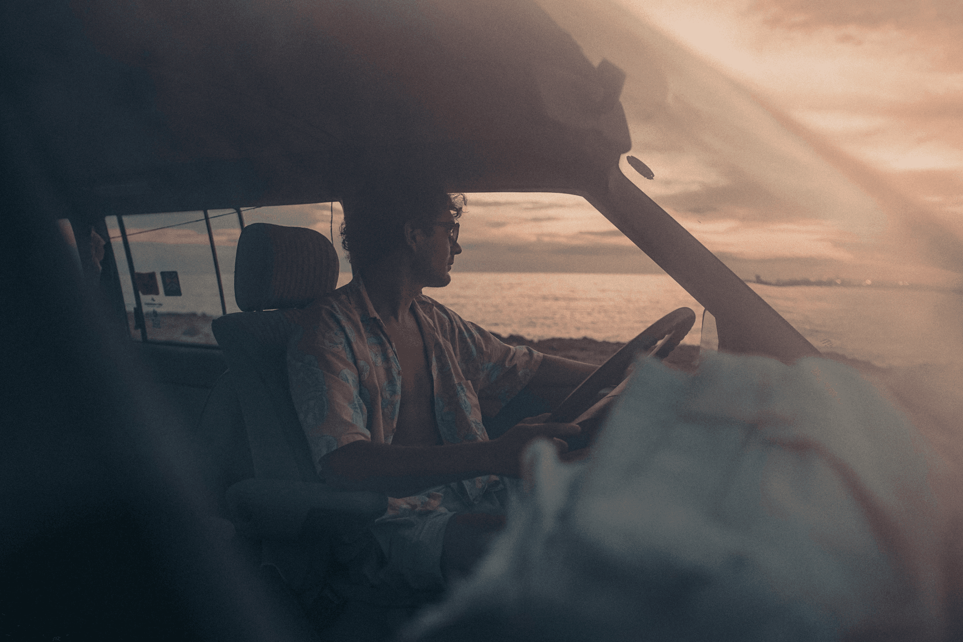 person in car by the ocean