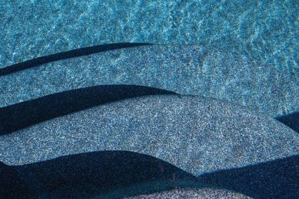Close view of blue pool water and the surface beneath it
