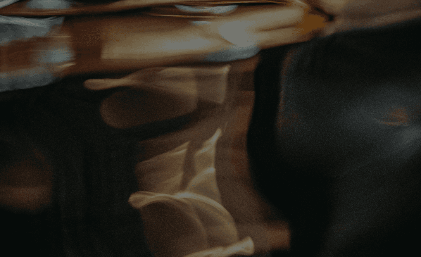 Abstract, motion-blurred image with warm brown and amber tones, creating a sense of movement and depth.