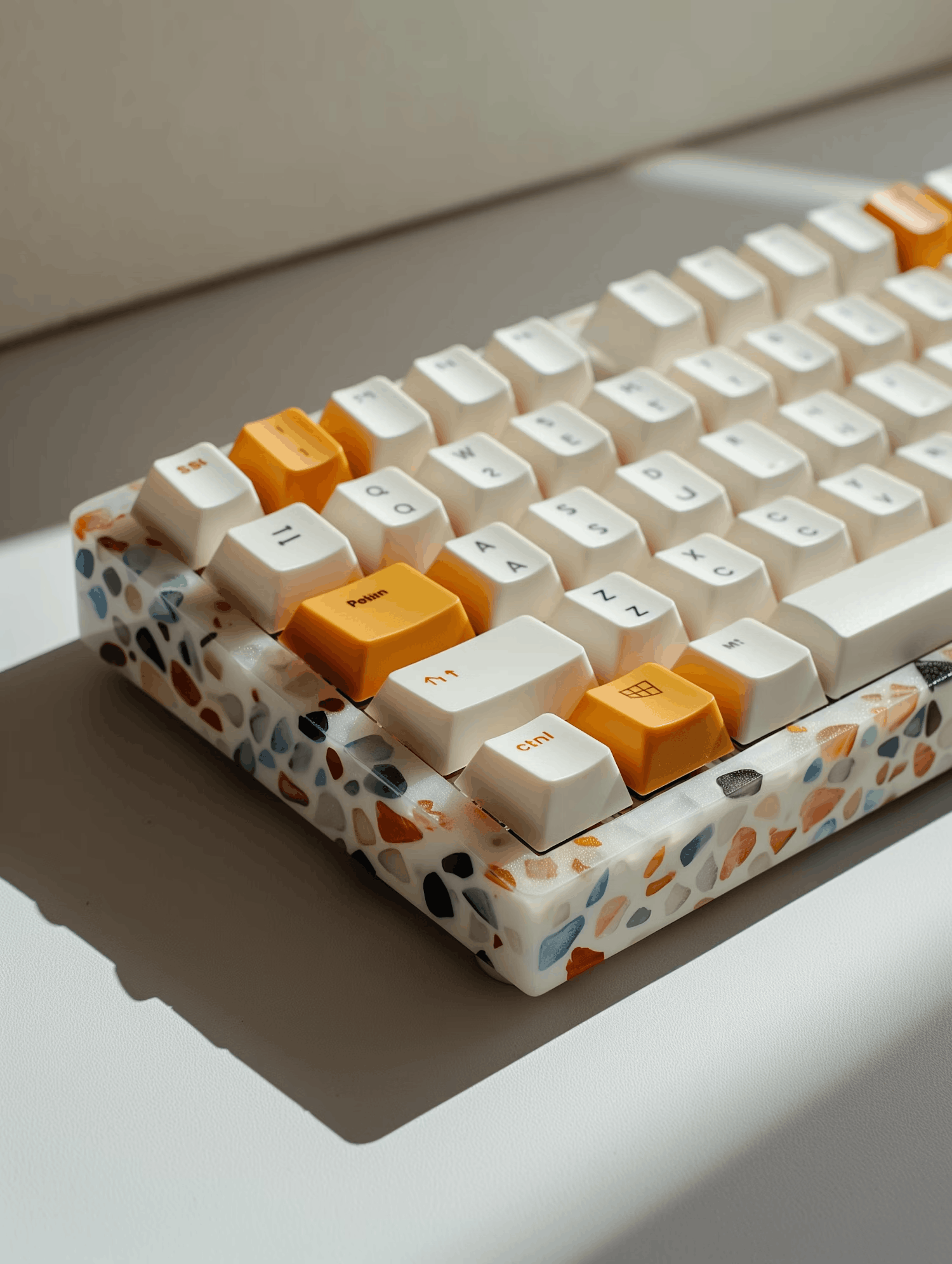 Keyboard with a terrazzo case and orange accent keycaps.