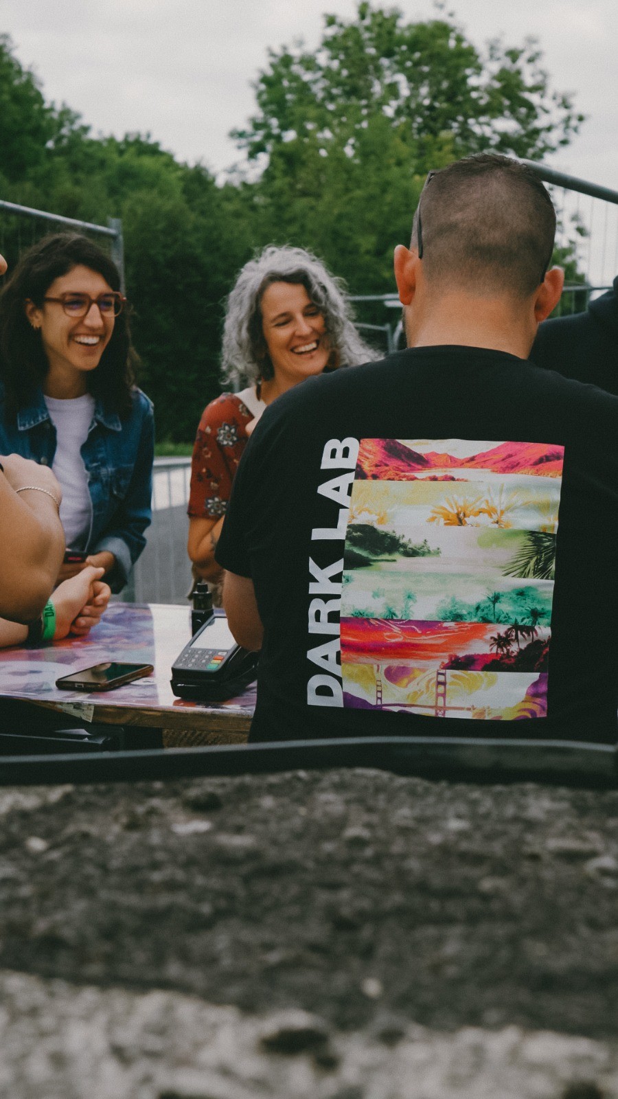 Homme de dos avec le tshirt Dark Lab et femmes qui sourient