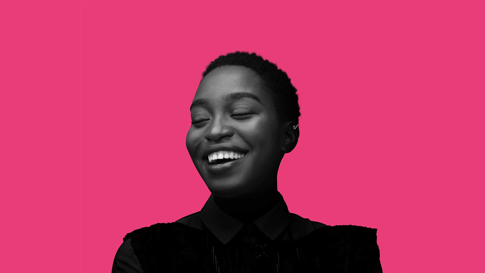 Black and white portrait of smiling person on pink background