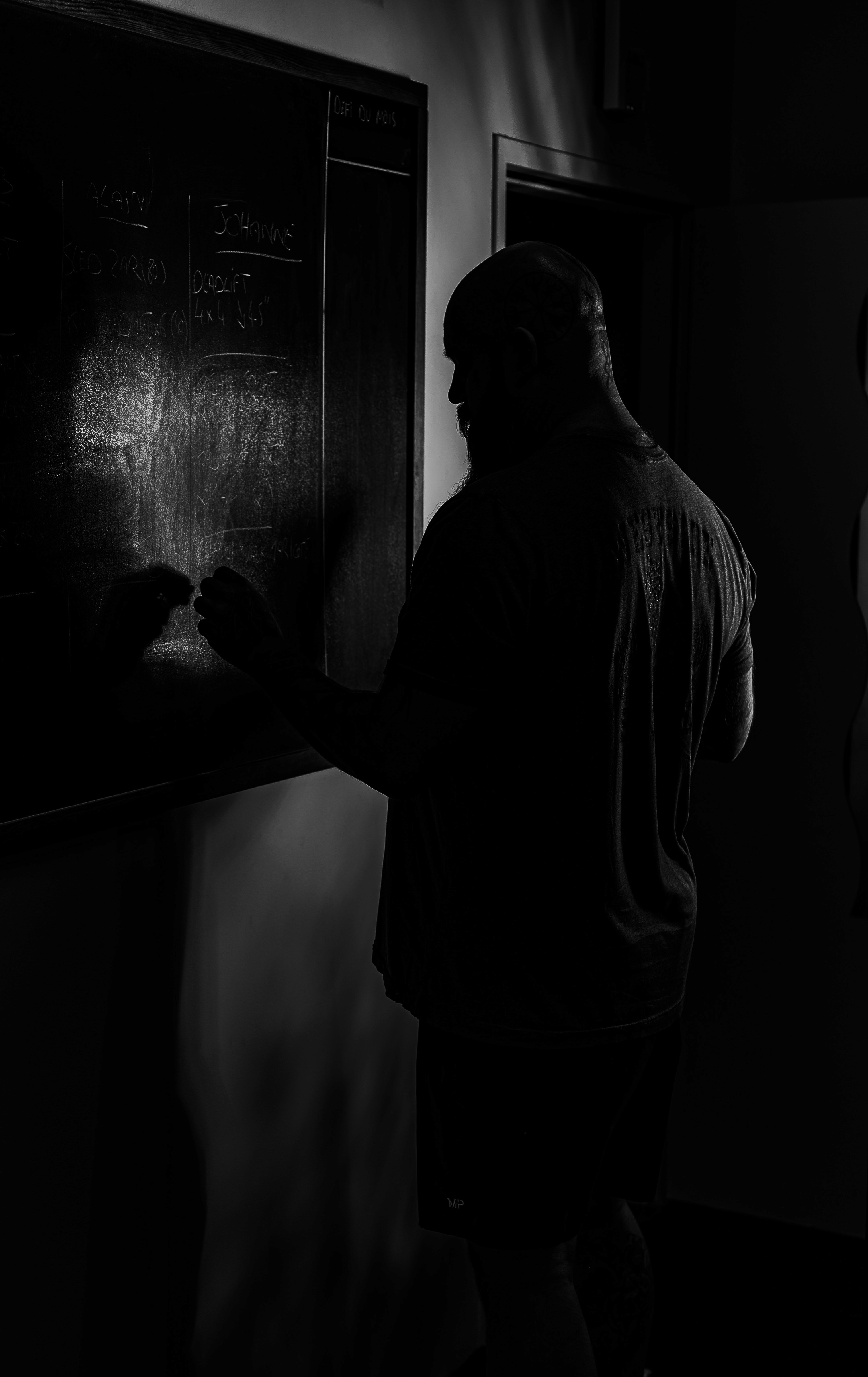 Two individuals are working out in a gym, focusing on dumbbells and strength training equipment.