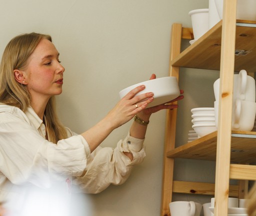 Kvinner som plukker keramikk fra en hylle