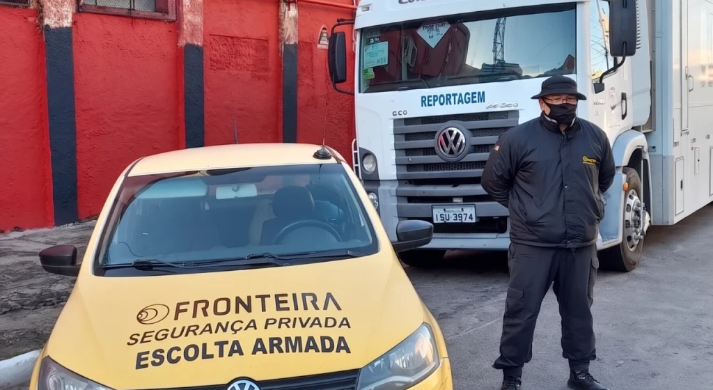 Segurança ao lado de um carro fazendo escolta.