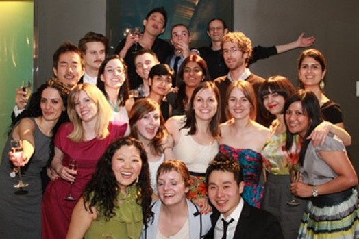 A photo of a group of people toasting champagne and smiling.