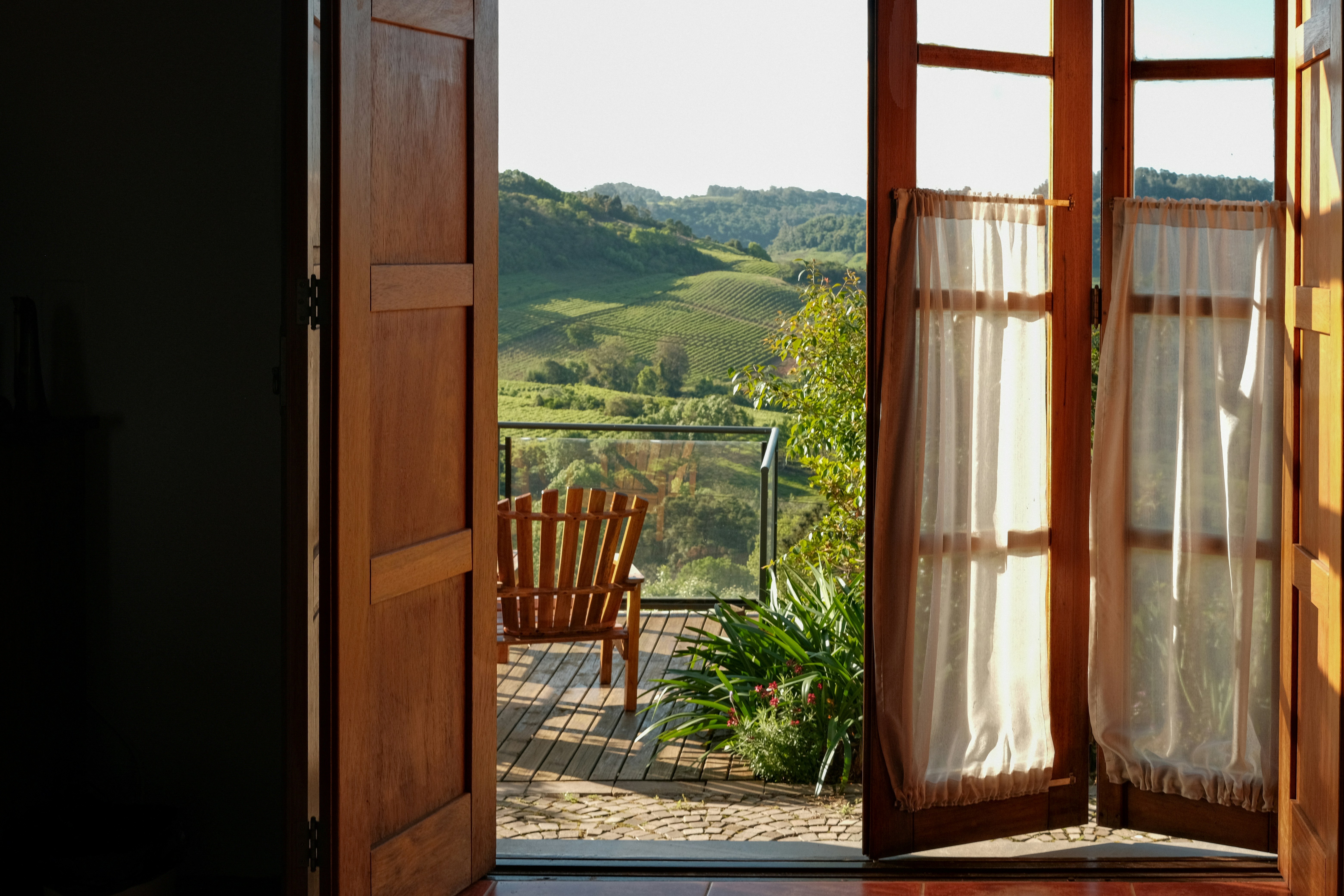 Open doors reveal a scenic view of rolling green hills.
