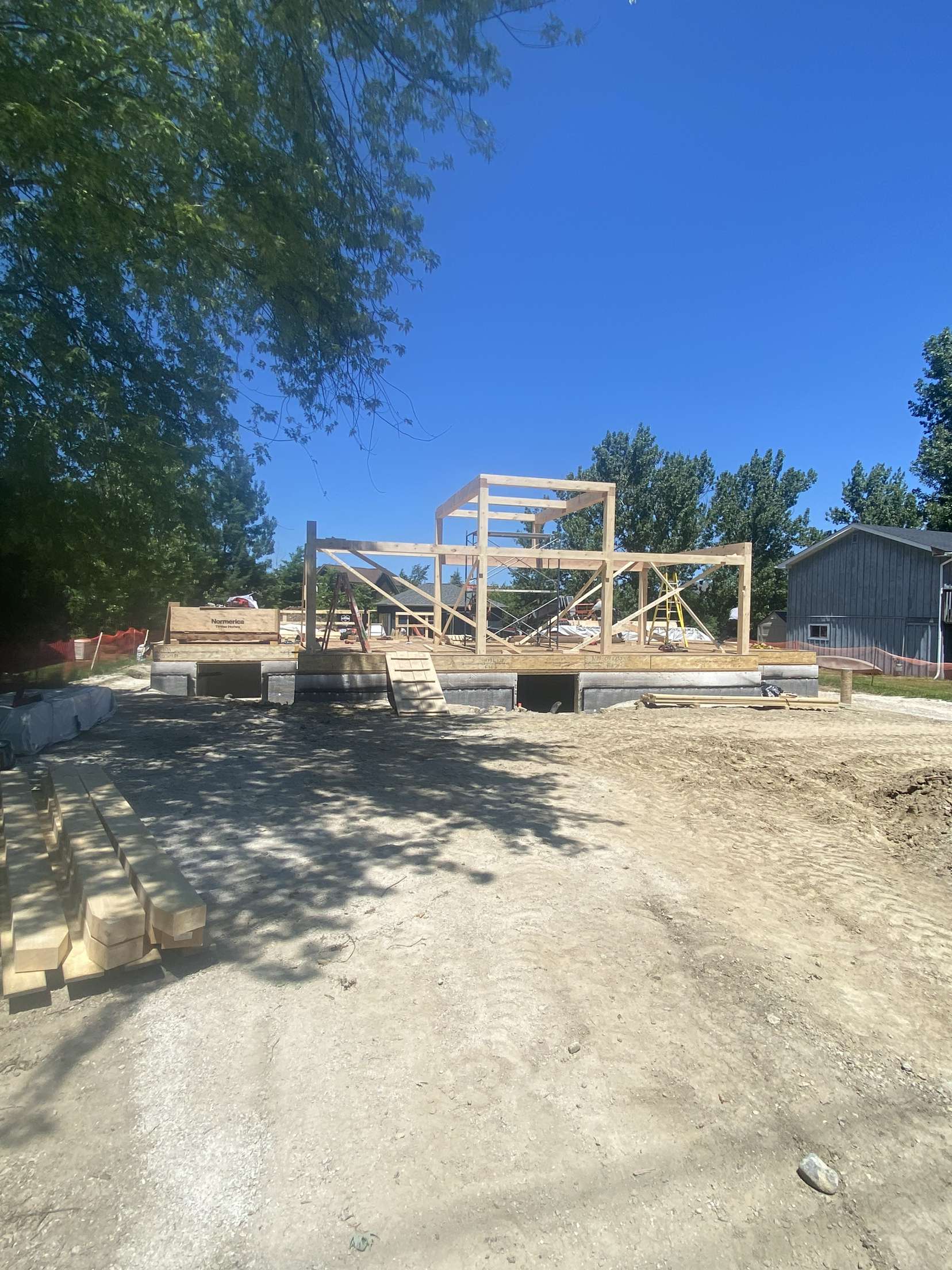 Timber frame construction underway by BWC Construction on a new residential build in Simcoe County, featuring structural wood framing on a prepared foundation.