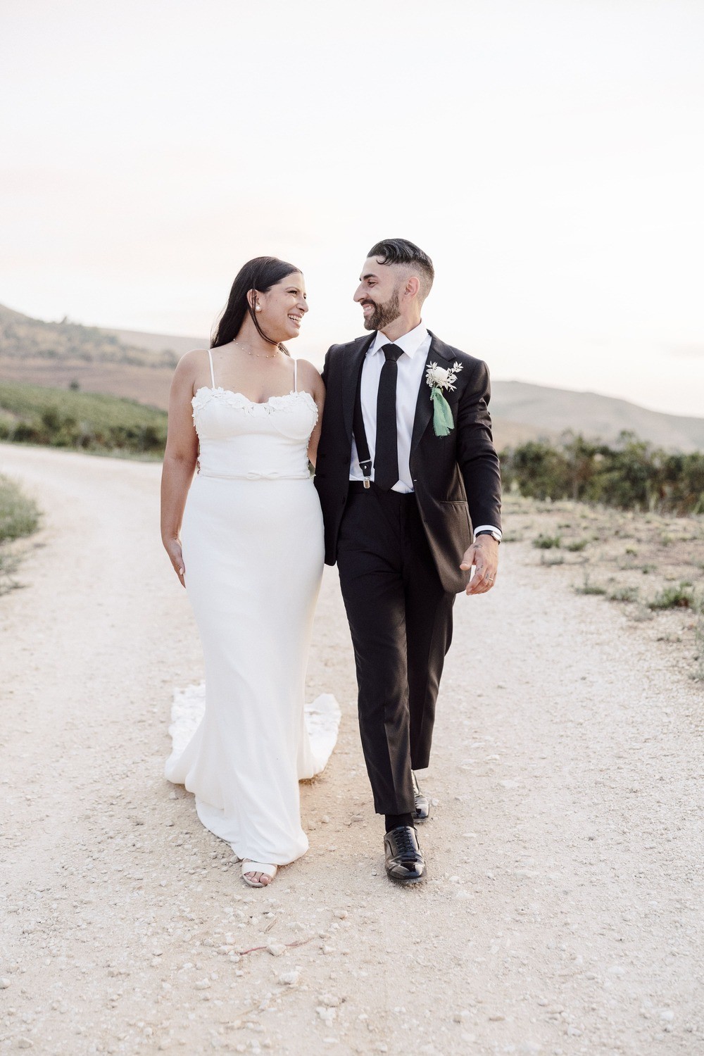 A bride in a lace wedding dress gently holds.
