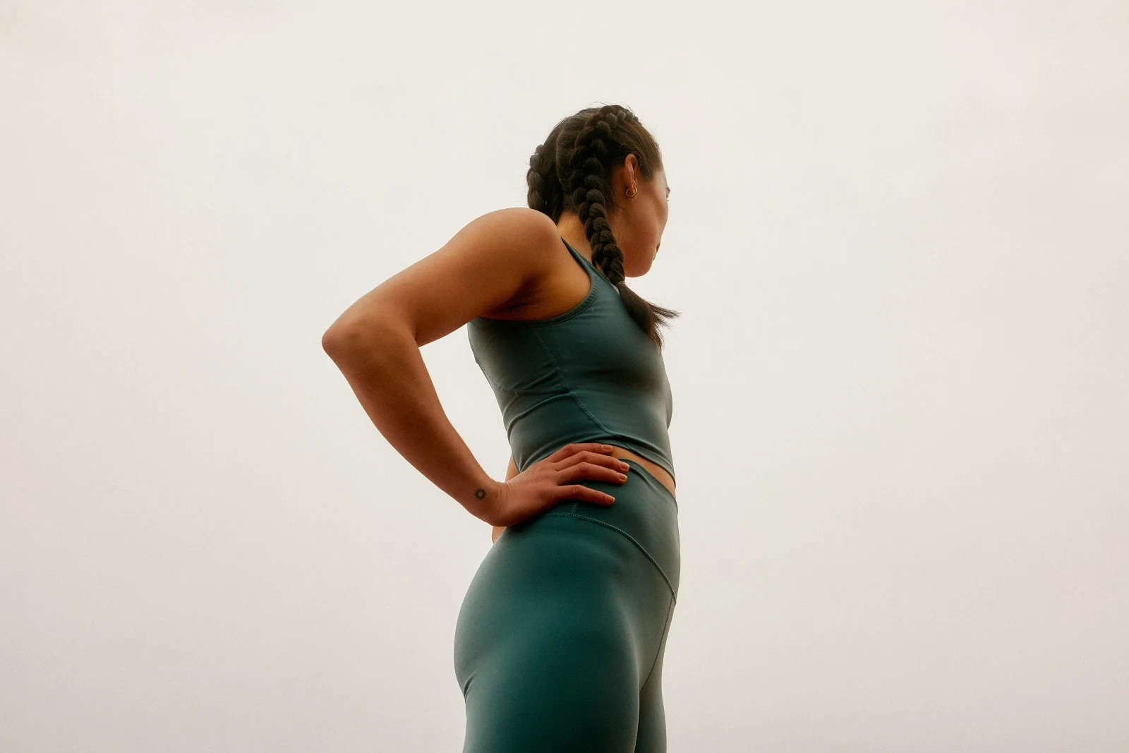 A woman in green activewear standing with her hands on her hips