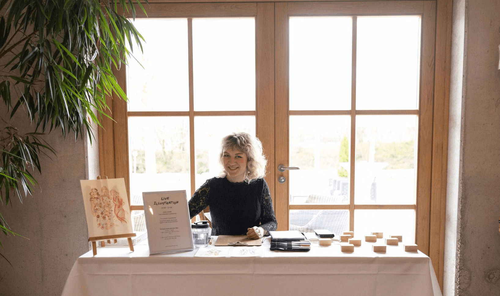 Die Illustratorin Vanessa Schumm an ihrem Arbeitsplatz bei einem Event – professionelle Live-Illustration für Hochzeiten in München und Umgebung