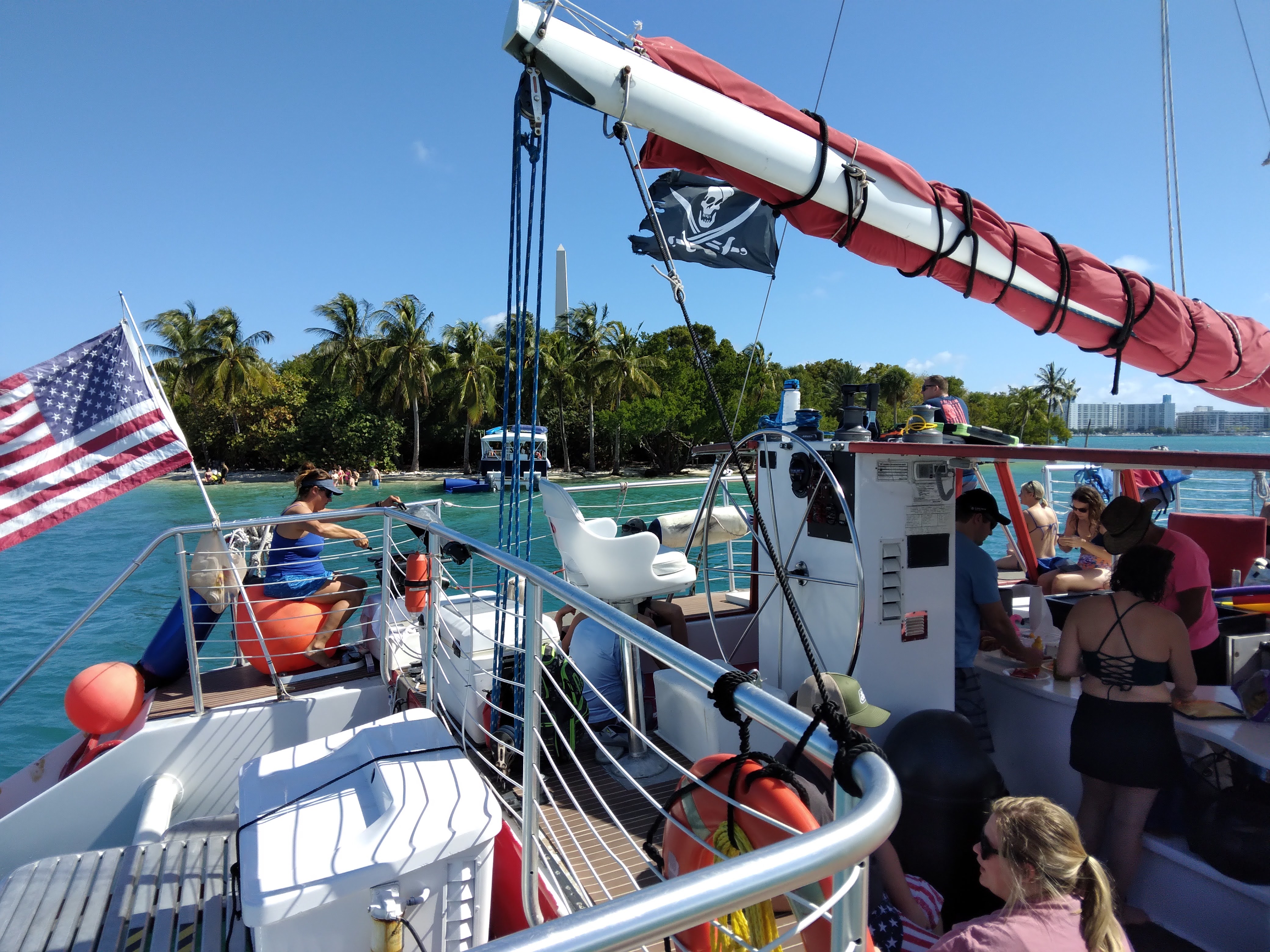 green and brown mountains near body of water under white clouds and blue sky during daytime