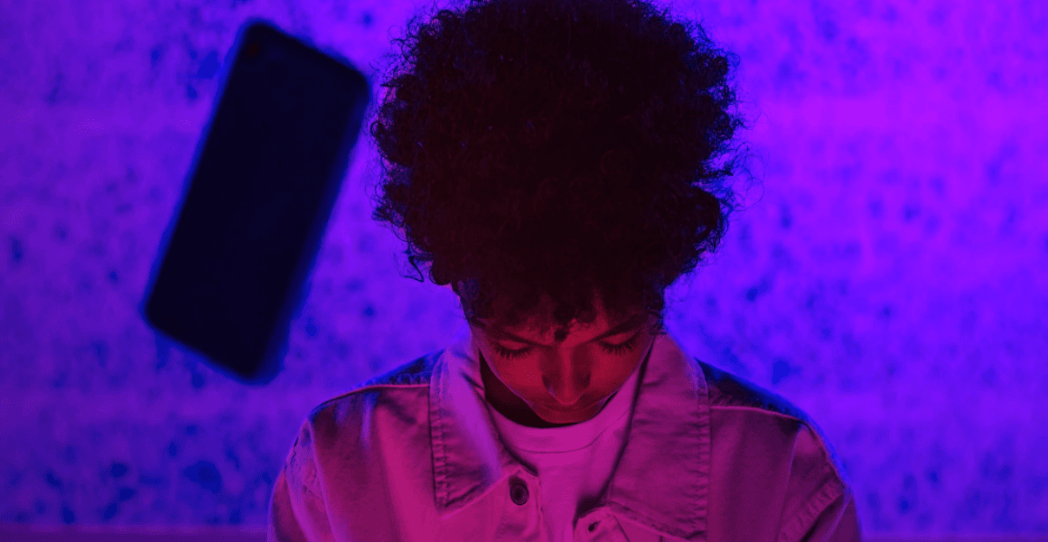 (Photo by Ron Lach) a somber kid in a jacket with a phone flying at their head