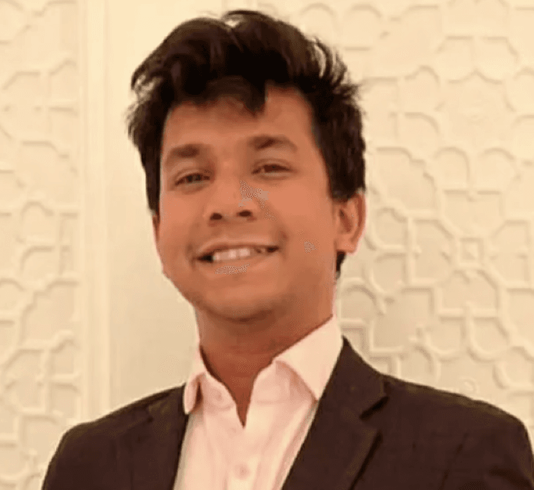 a man with a goatee smiles at the camera