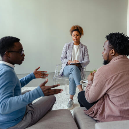 Two person talking to each other while a therapist is listening