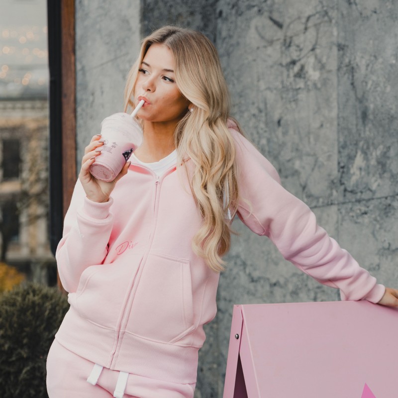 Influencer Emma Ellingsen holding a pink smoothe and wearing pink ziphood and pink sweatpants from Russemerch