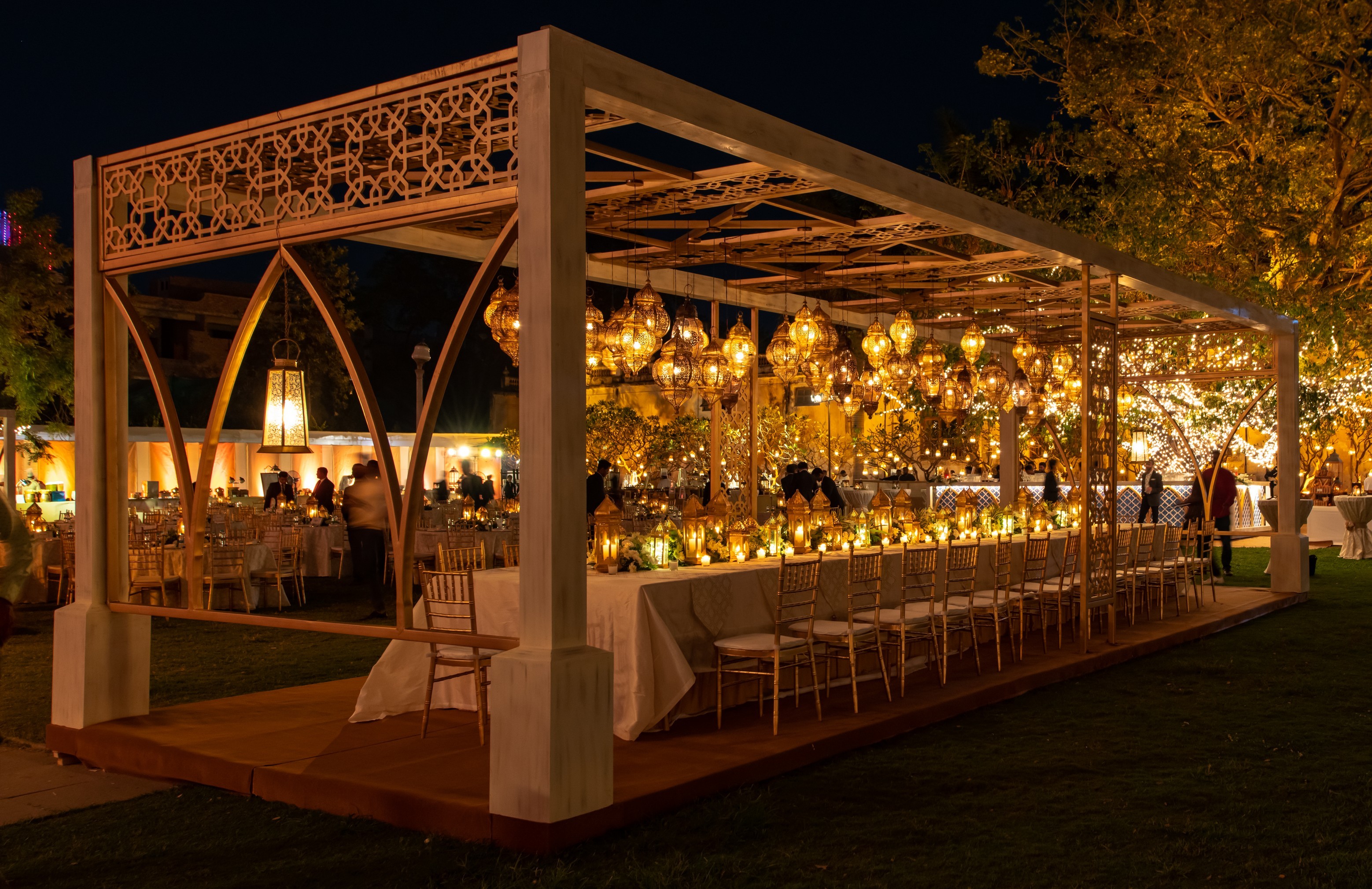 A rustic kitchen scene featuring glass jars of sourdough starter on a wooden table, with a notebook filled with handwritten recipes, a brown bowl of flour, and a beige fabric apron, illuminated by soft natural light from a window.