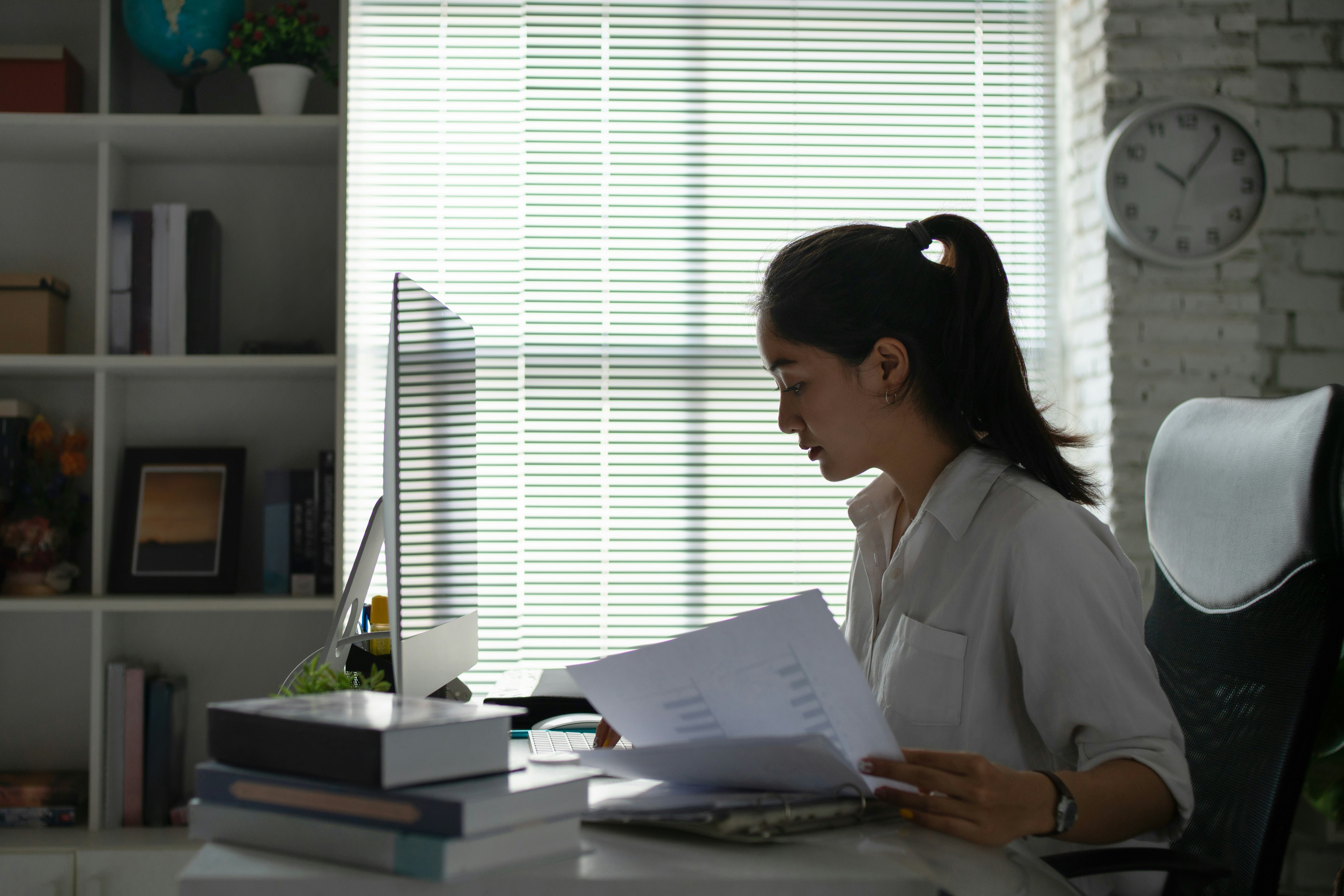 woman sitting at office desk working with documents