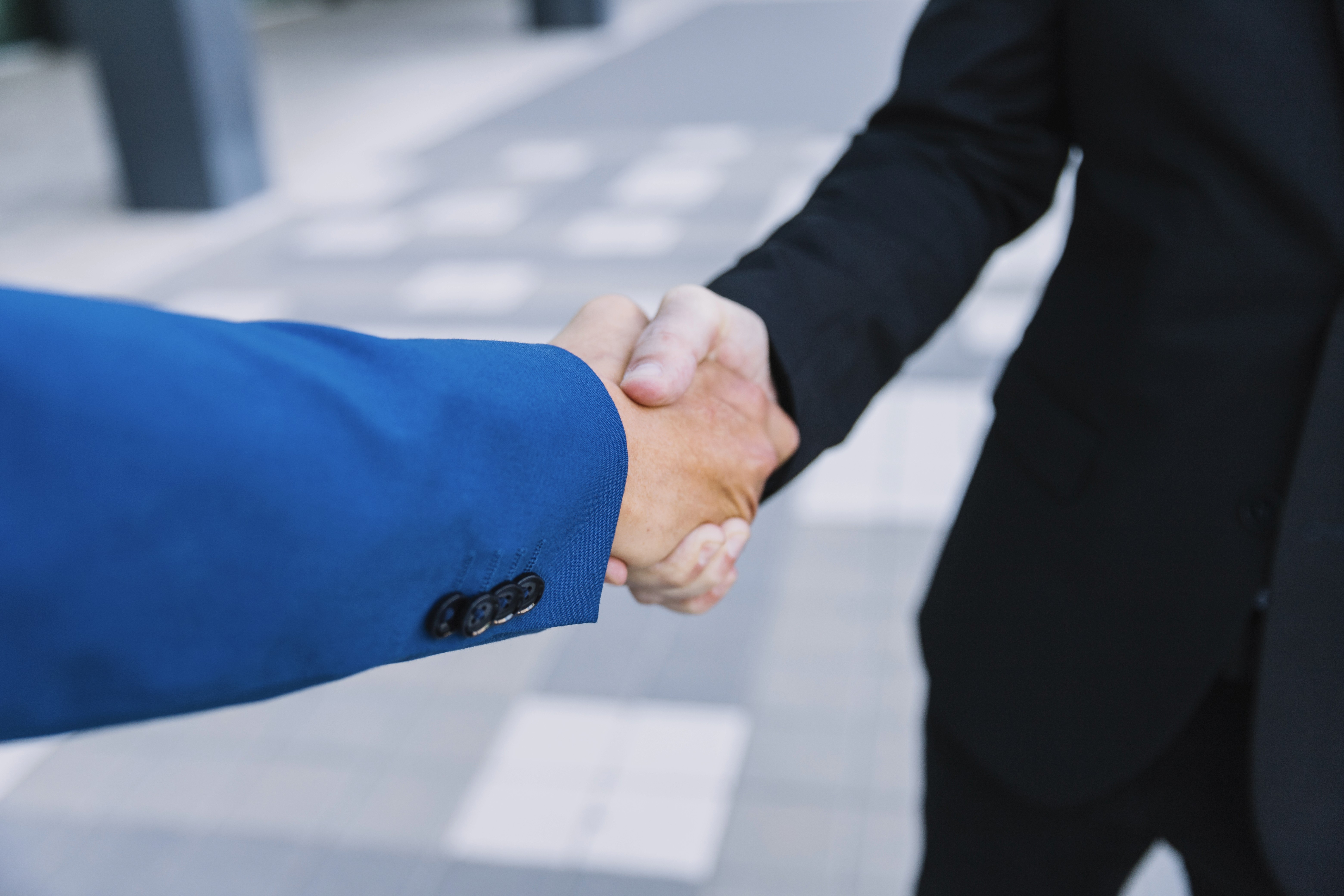 Handdruk van twee mannen in pak