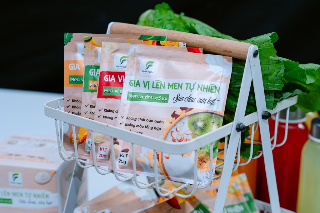 person in orange jacket standing on brown rock near snow covered mountain during daytime