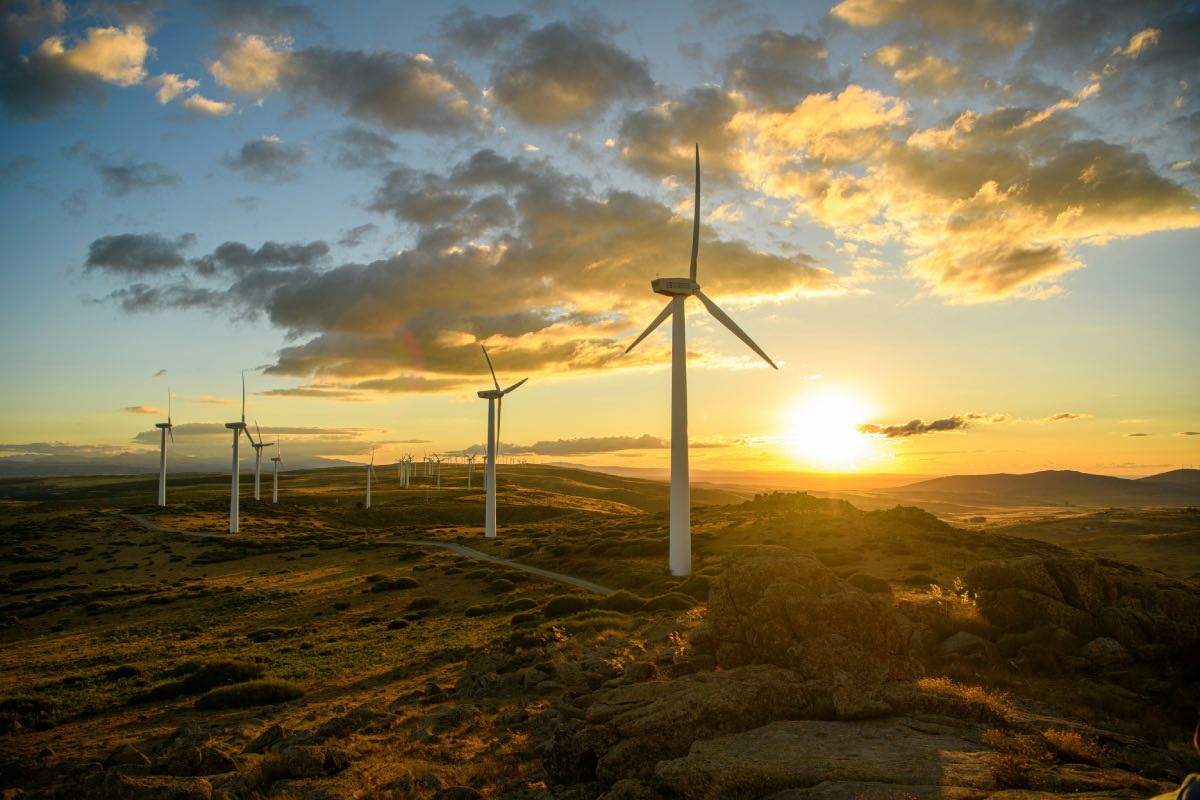 een lijn van windmolens in een plattelandsgebied, tijdens zonsondergang
