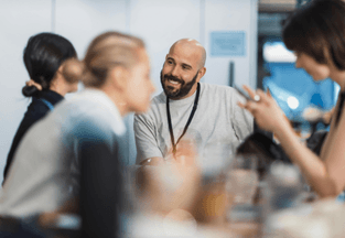 A diverse group of people collaborating around a table, discussing ideas and analyzing documents together.