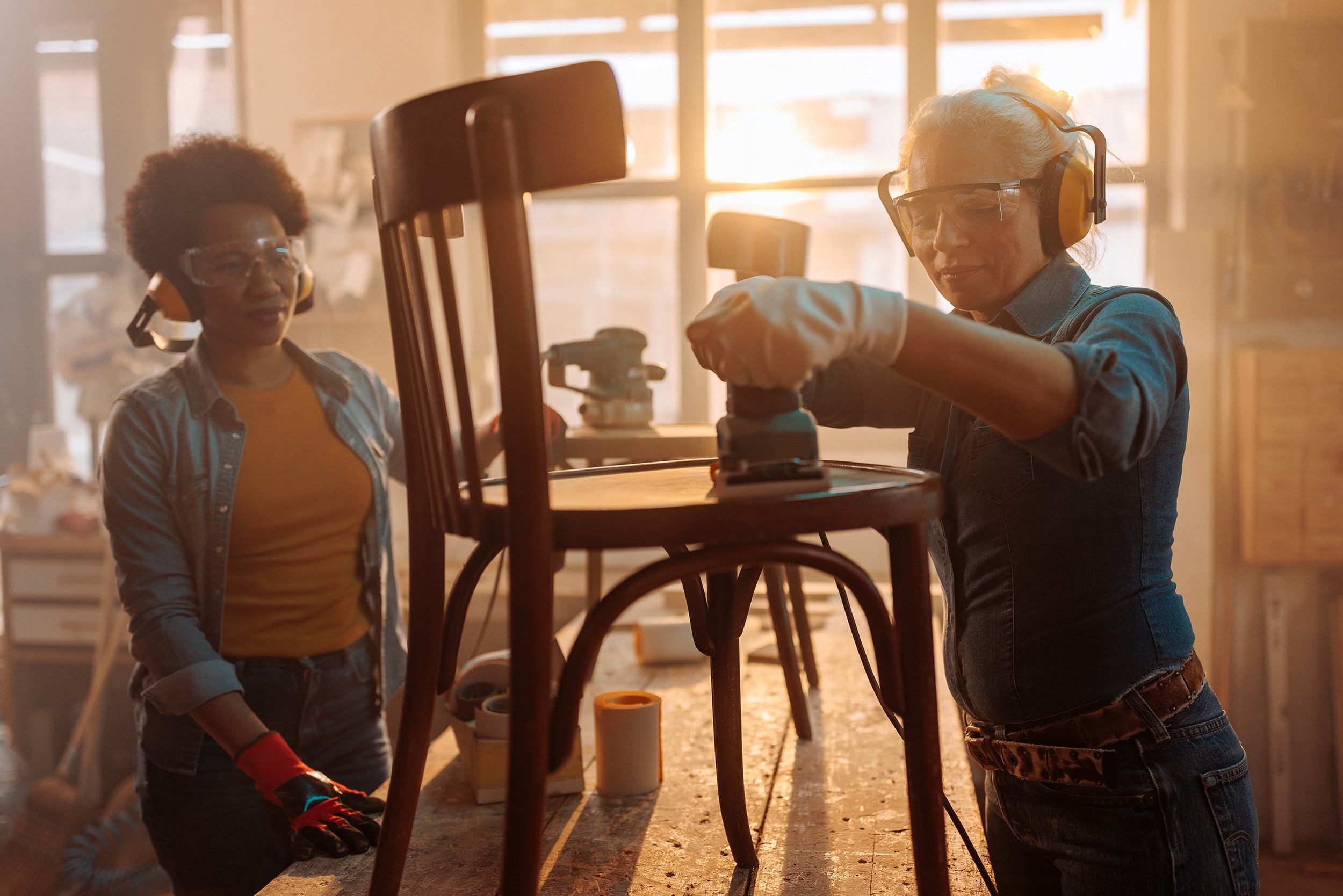 Photo of coworkers refurbishing furniture. 