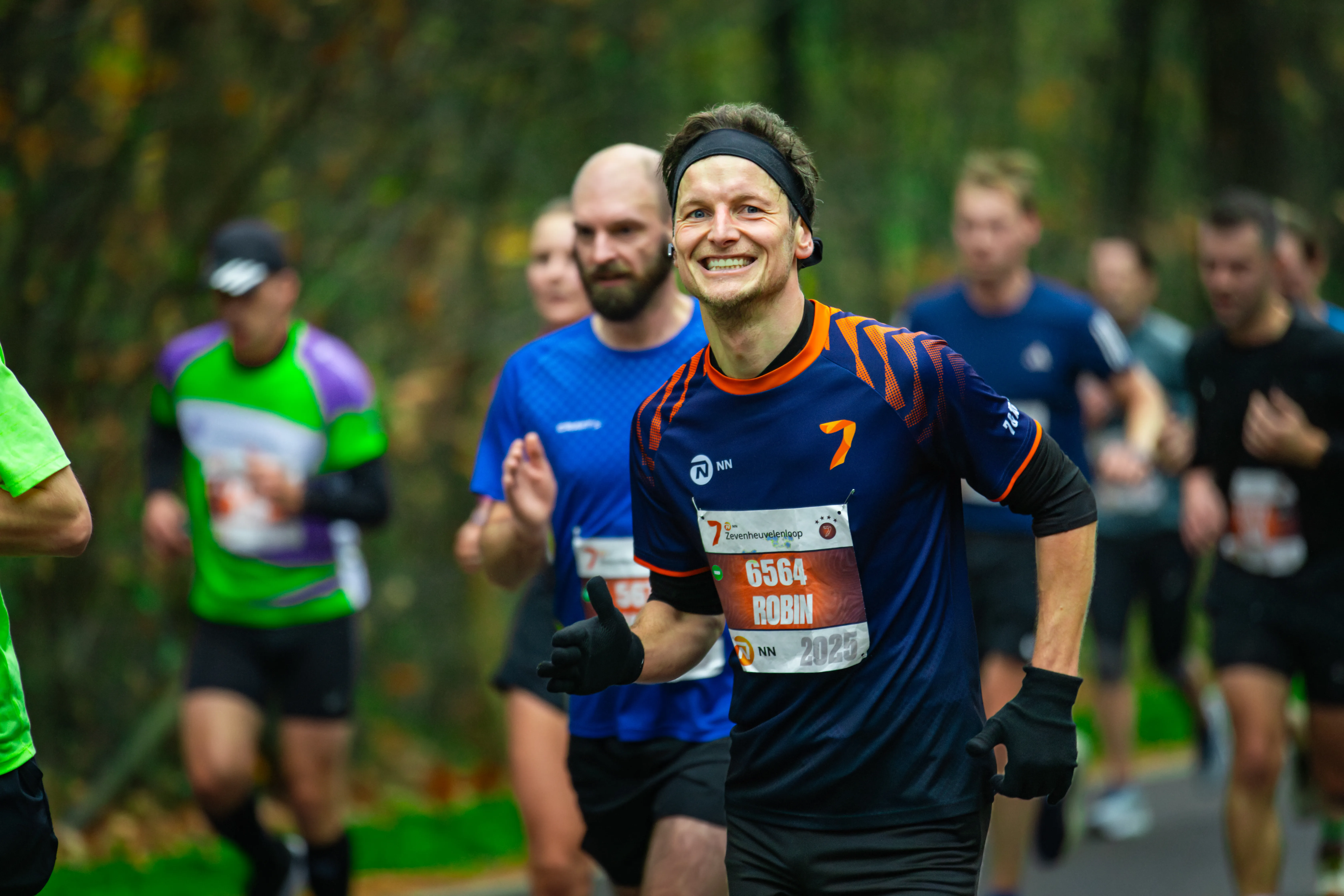 een deelnemer van de zevenheuvelenloop 2025 lachend naar de camera