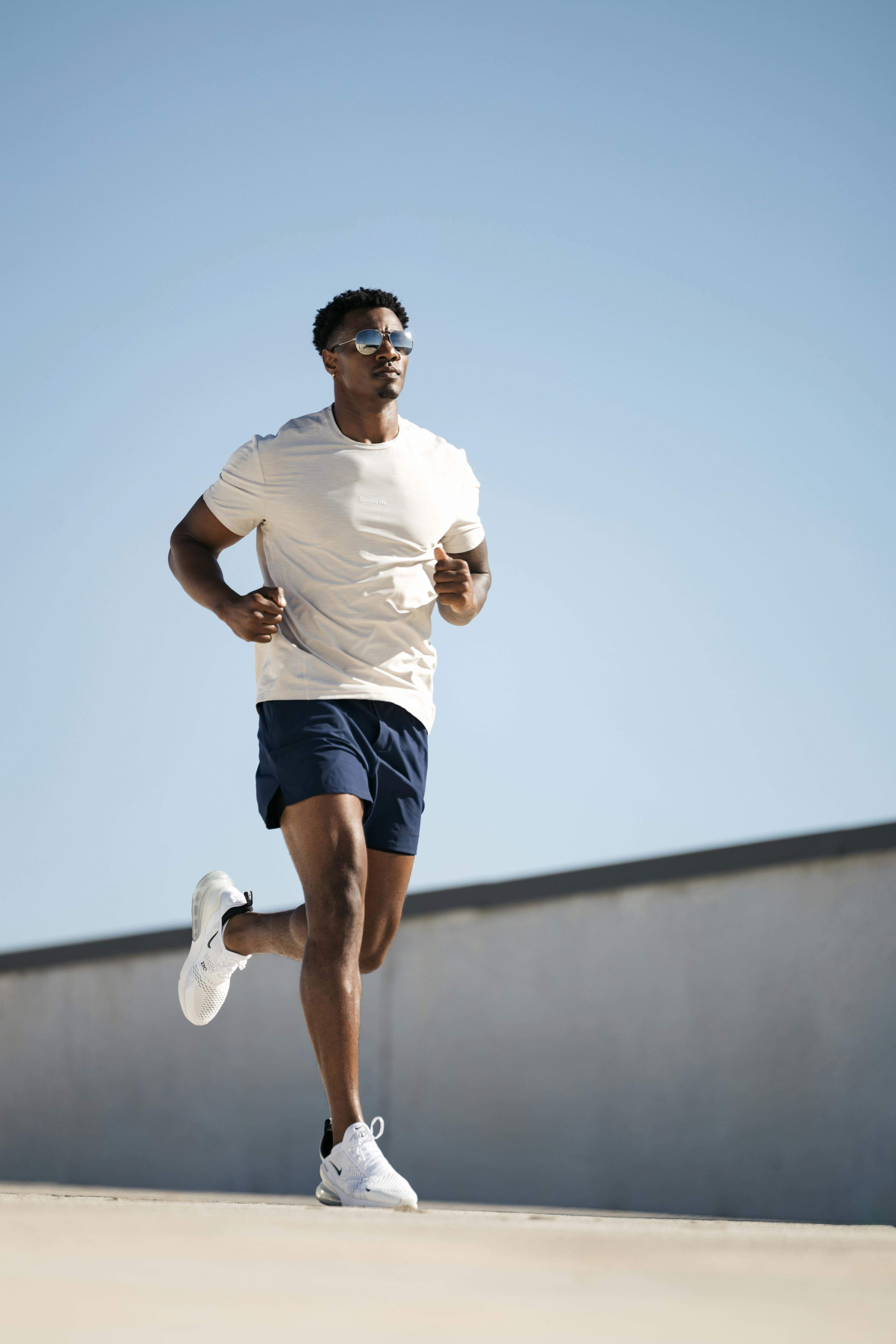 Man running in a sports outfit in a sunny environment.