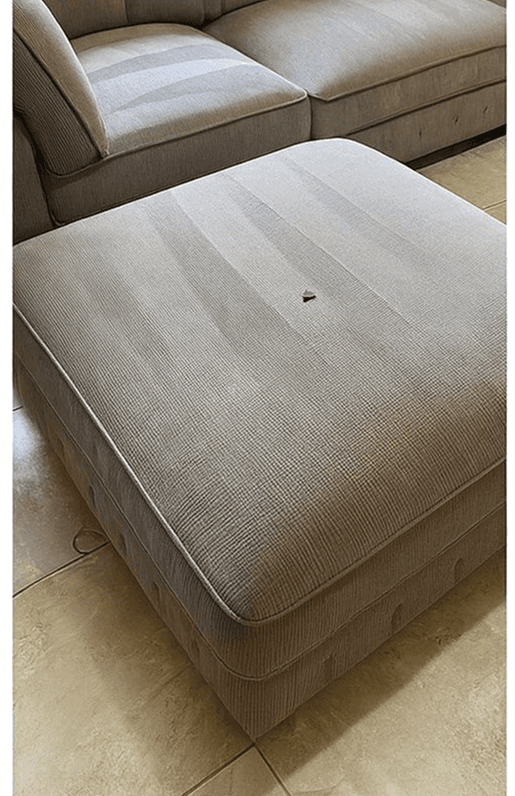 a person in white gloves is cleaning a chair