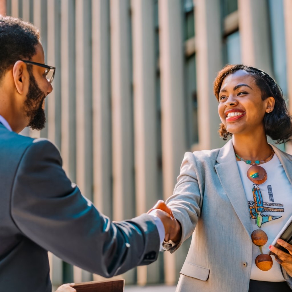 A person shaking hands with an attorney with a globe or map in the background.