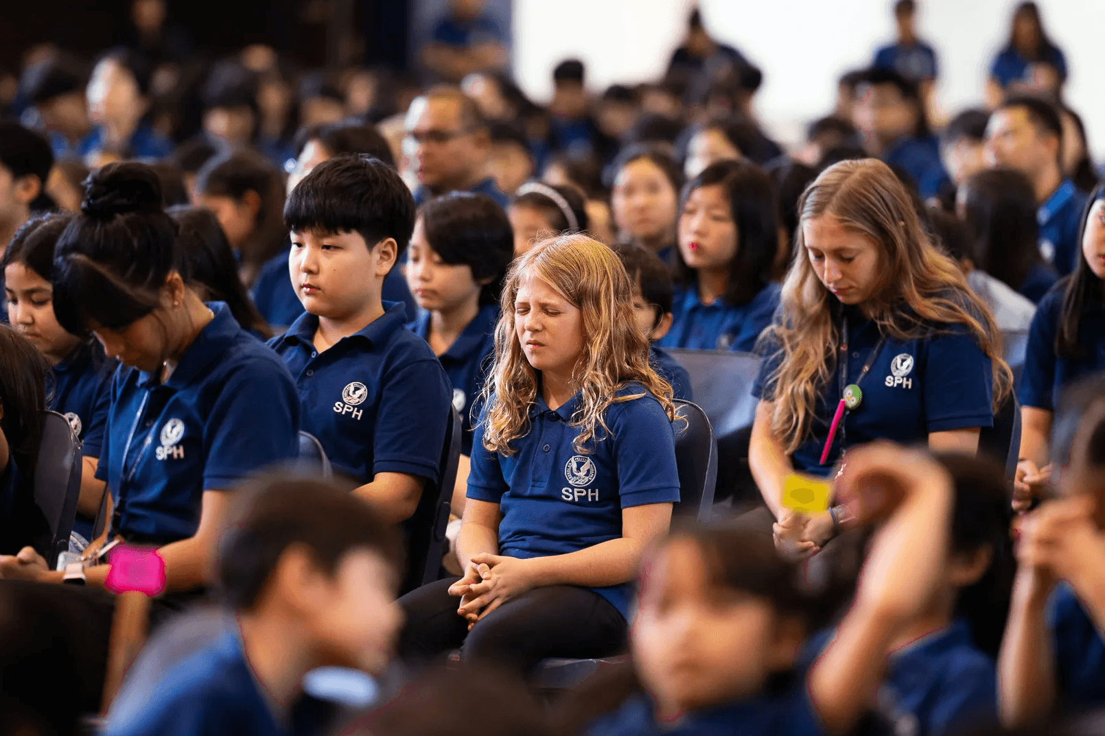 person writing on brown wooden table near white ceramic mug