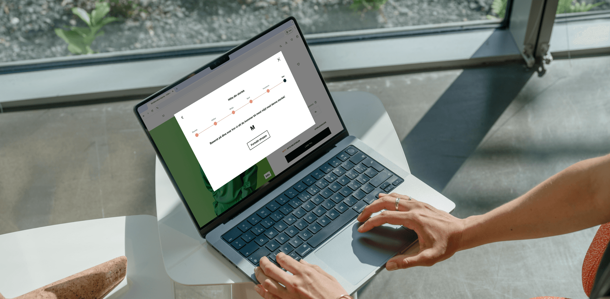 A person using a laptop to complete the "Find My Size" feature, selecting a recommended size based on previous inputs. The screen displays the final size suggestion with a confirmation button.