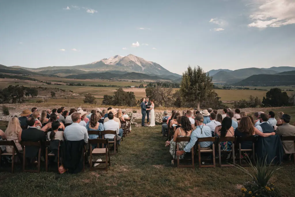Outdoor wedding ceremony overlooking a broad mountain valley