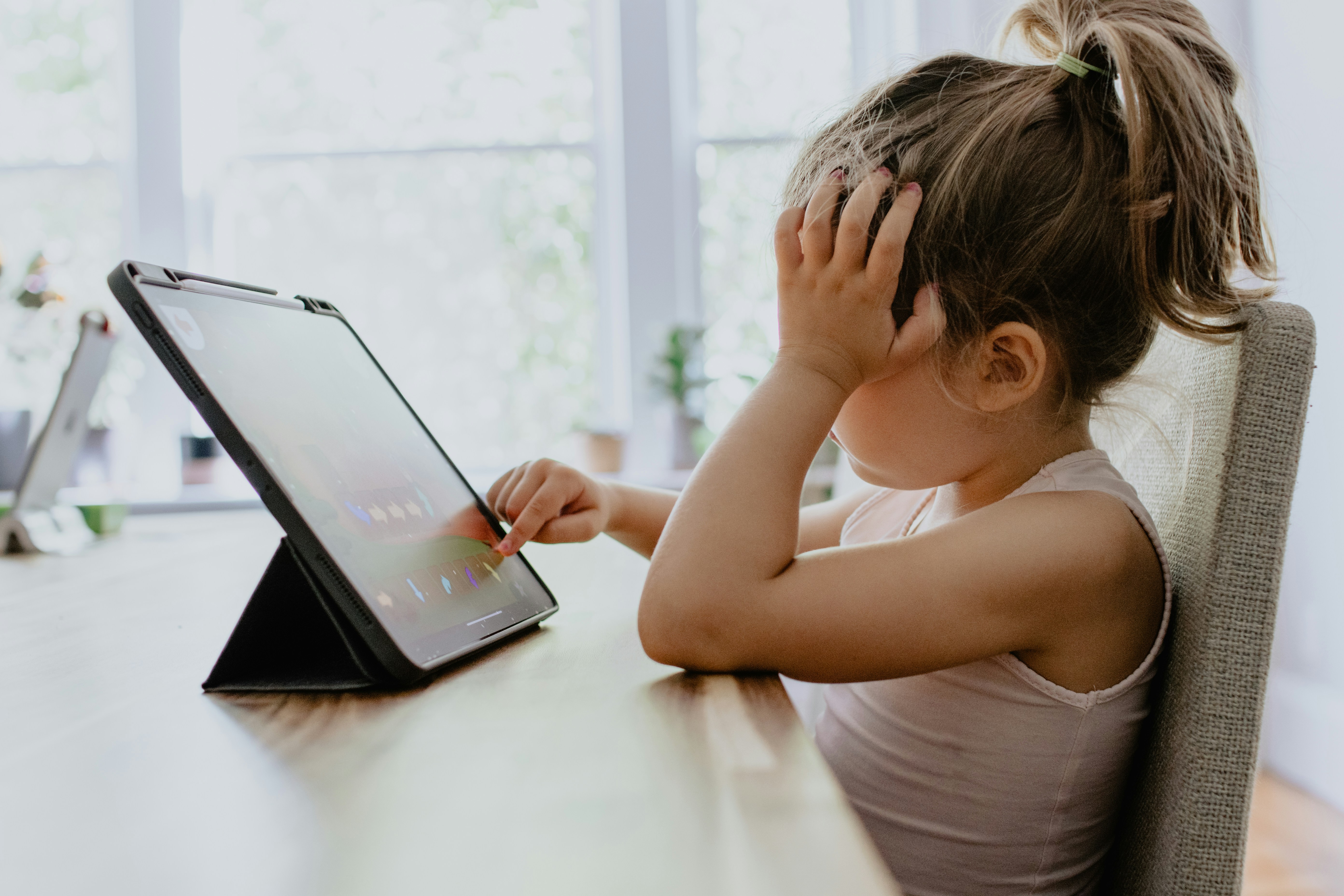 Child sitting at a table on an ipad