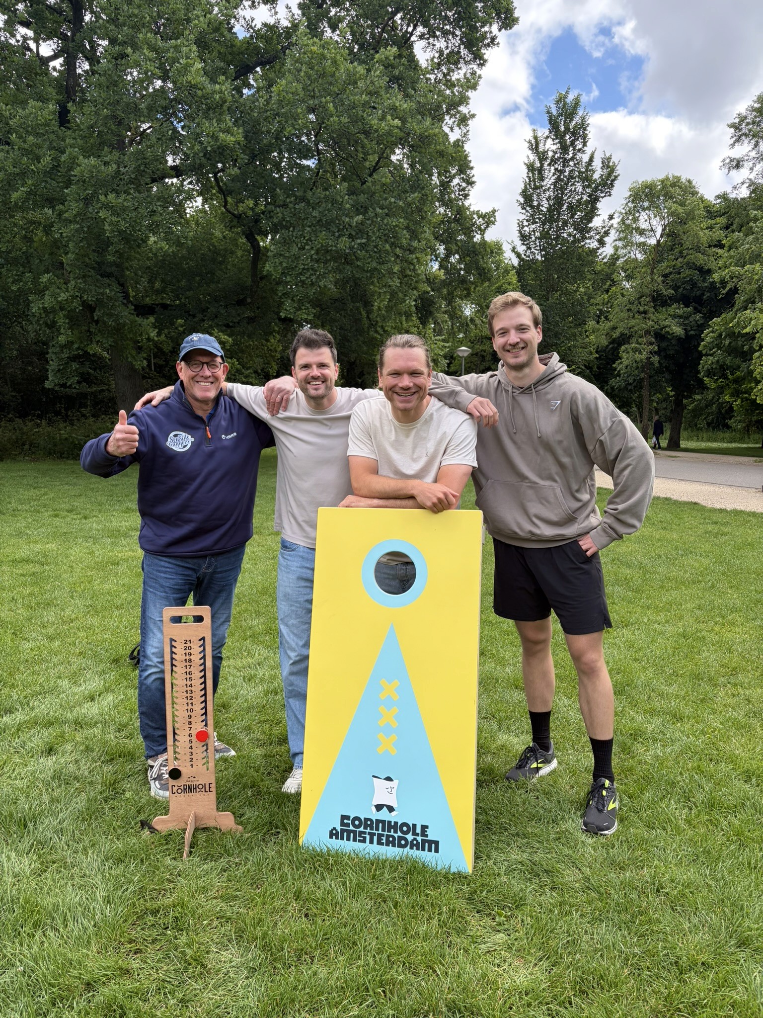 The Cornhole Amsterdam team with custom cornhole boards in a park in Amsterdam