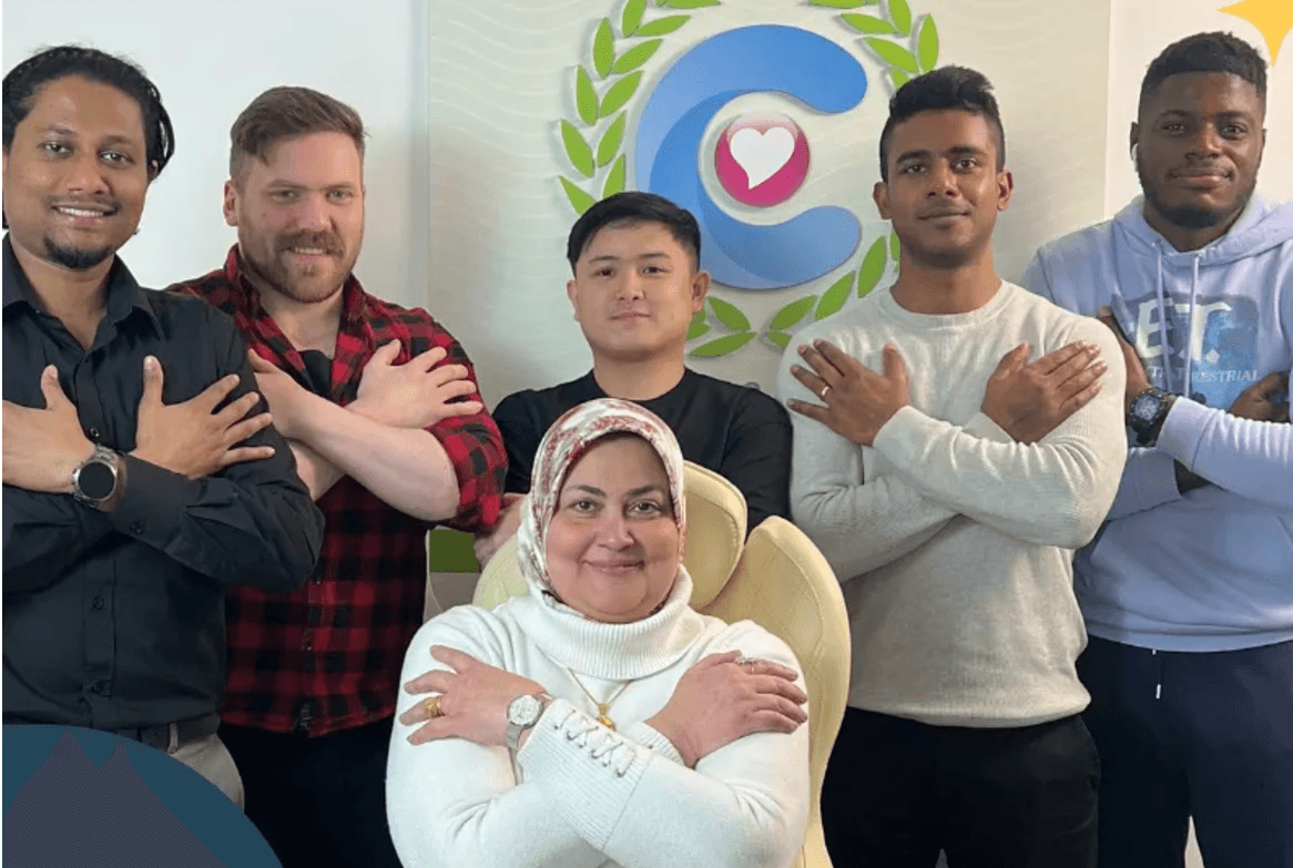 Some of the Carrik Care team posing with crossed arms in front of the Carrik Care logo