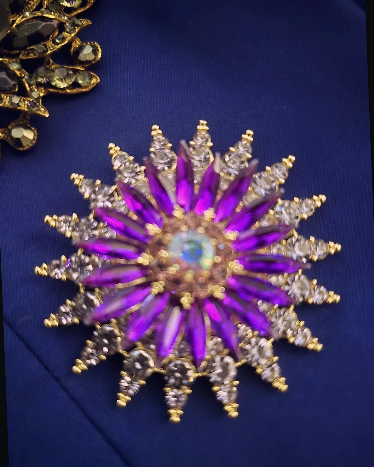 Macro photograph of the original purple starburst brooch attached to the Wonder Suit fabric.