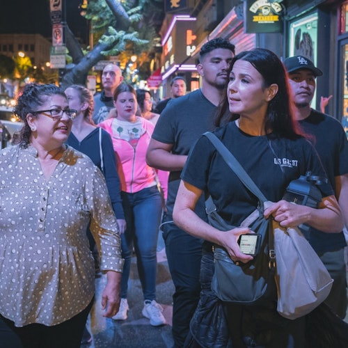 Tour guide leading her group to their next location while telling the history of the city
