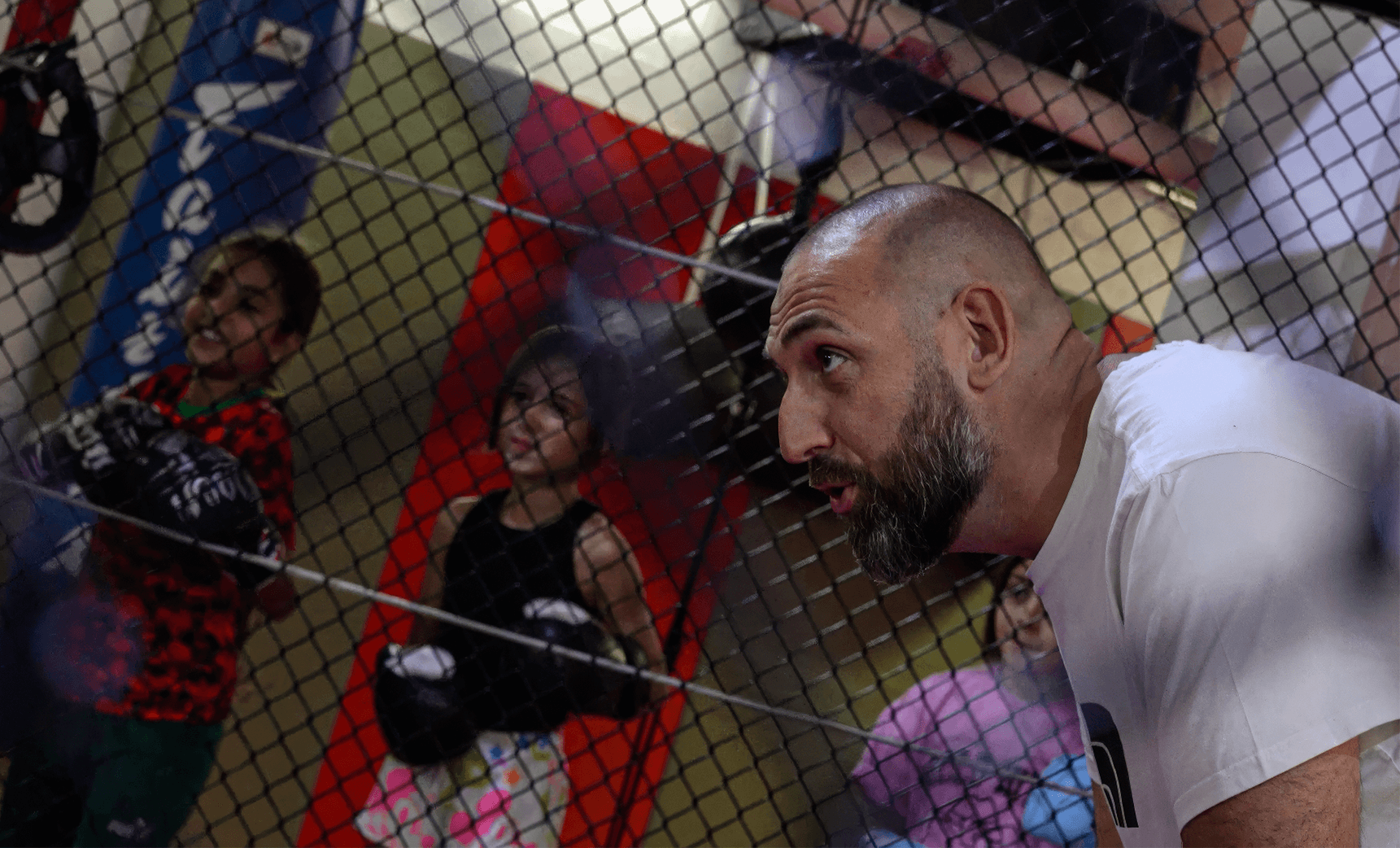 MMA coach giving instructions to children during a training session