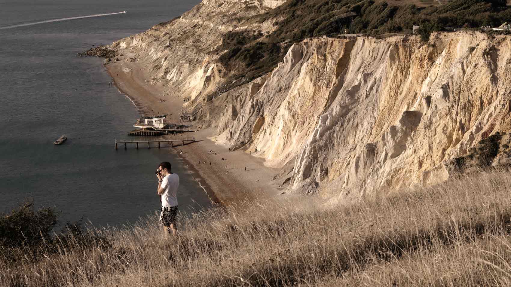 A photographer in the dunes taking a photograph of a sunset