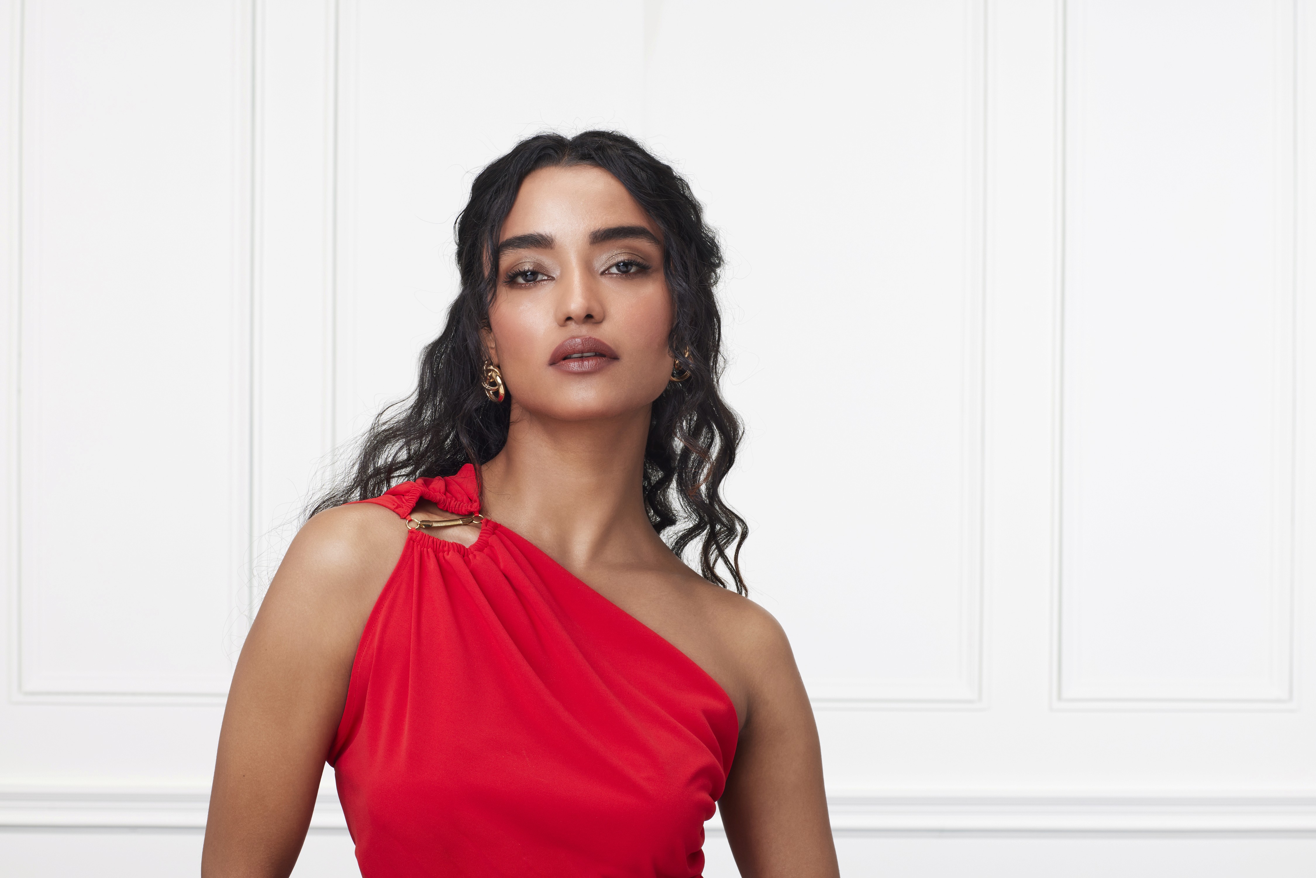 Green car under neon lights in a rainy city street