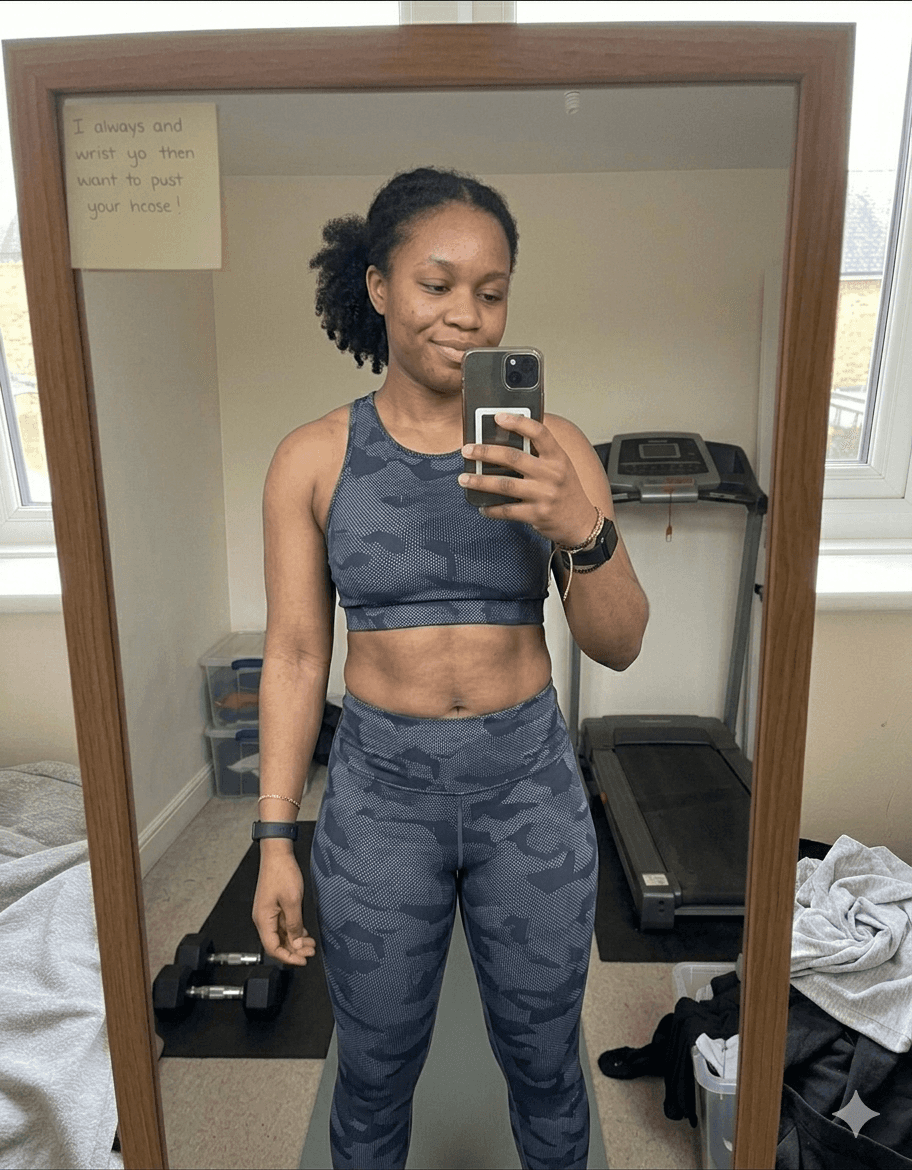 Chloe after fitness transformation – mirror selfie showing toned abs and slimmer waist in sports bra and grey legging