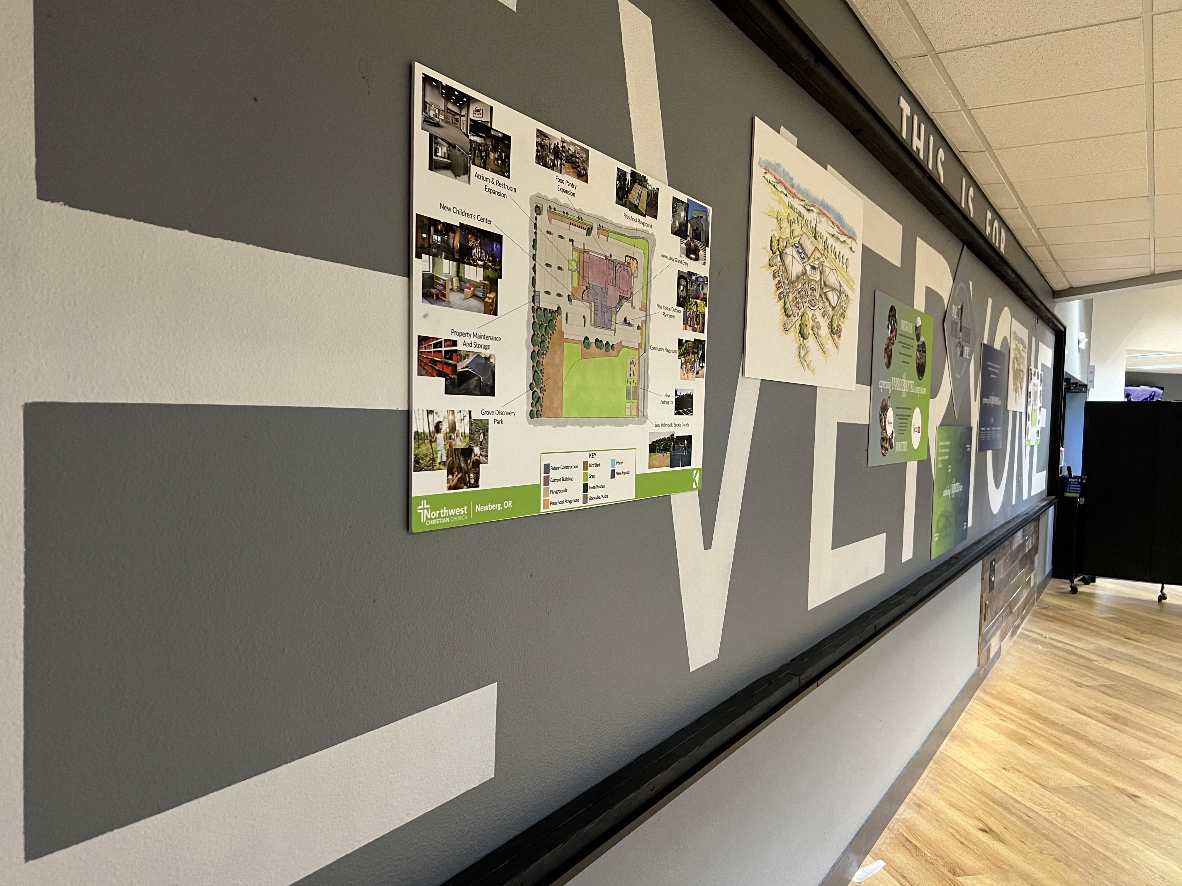 Modern home office setup with a monitor, ergonomic chair, keyboard, and indoor plants near a window with blinds.
