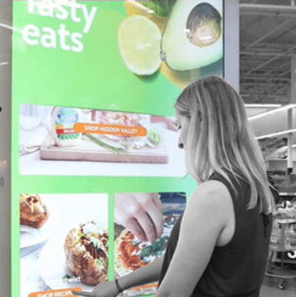 A person using a touch screen in a grocery store