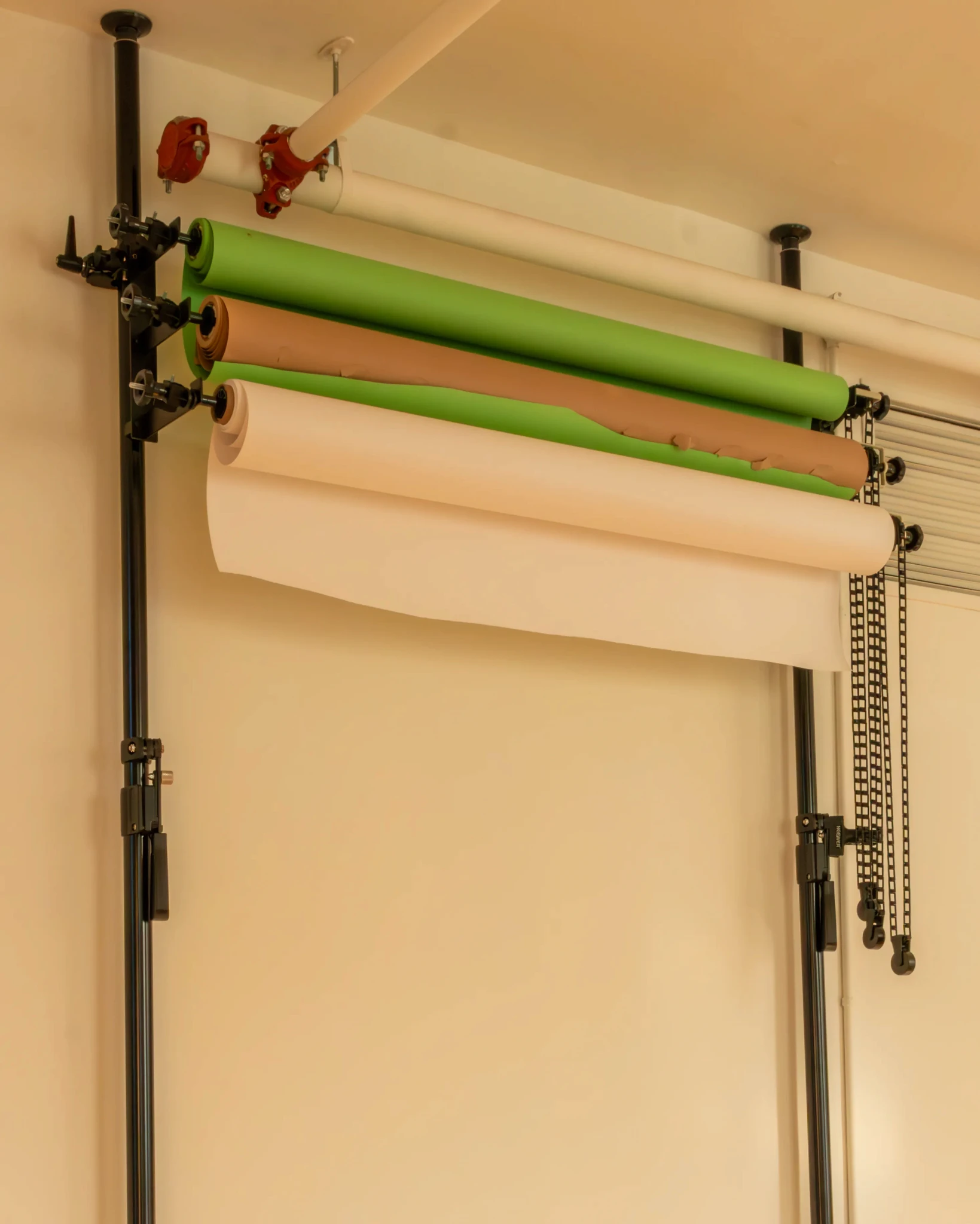 Backdrop setup at Node Studio featuring multiple color options, including green, brown, and white, mounted on a seamless roller system for professional photoshoots and content creation