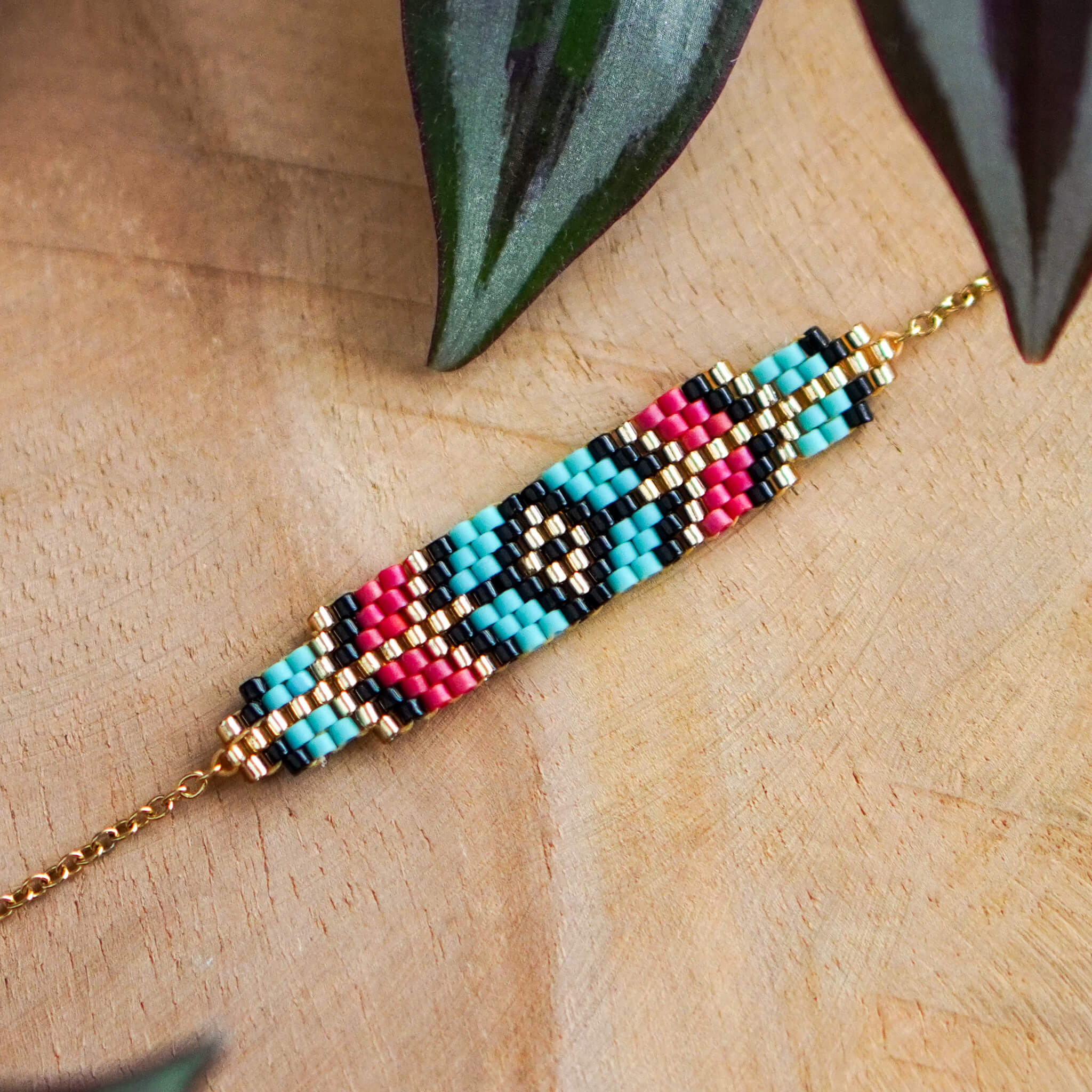 Bransoletka Berry Prism z geometrycznym wzorem w kolorach malinowej czerwieni i jasnego niebieskiego, wykonana z koralików Miyuki na szłotym łańcuszku ze stali