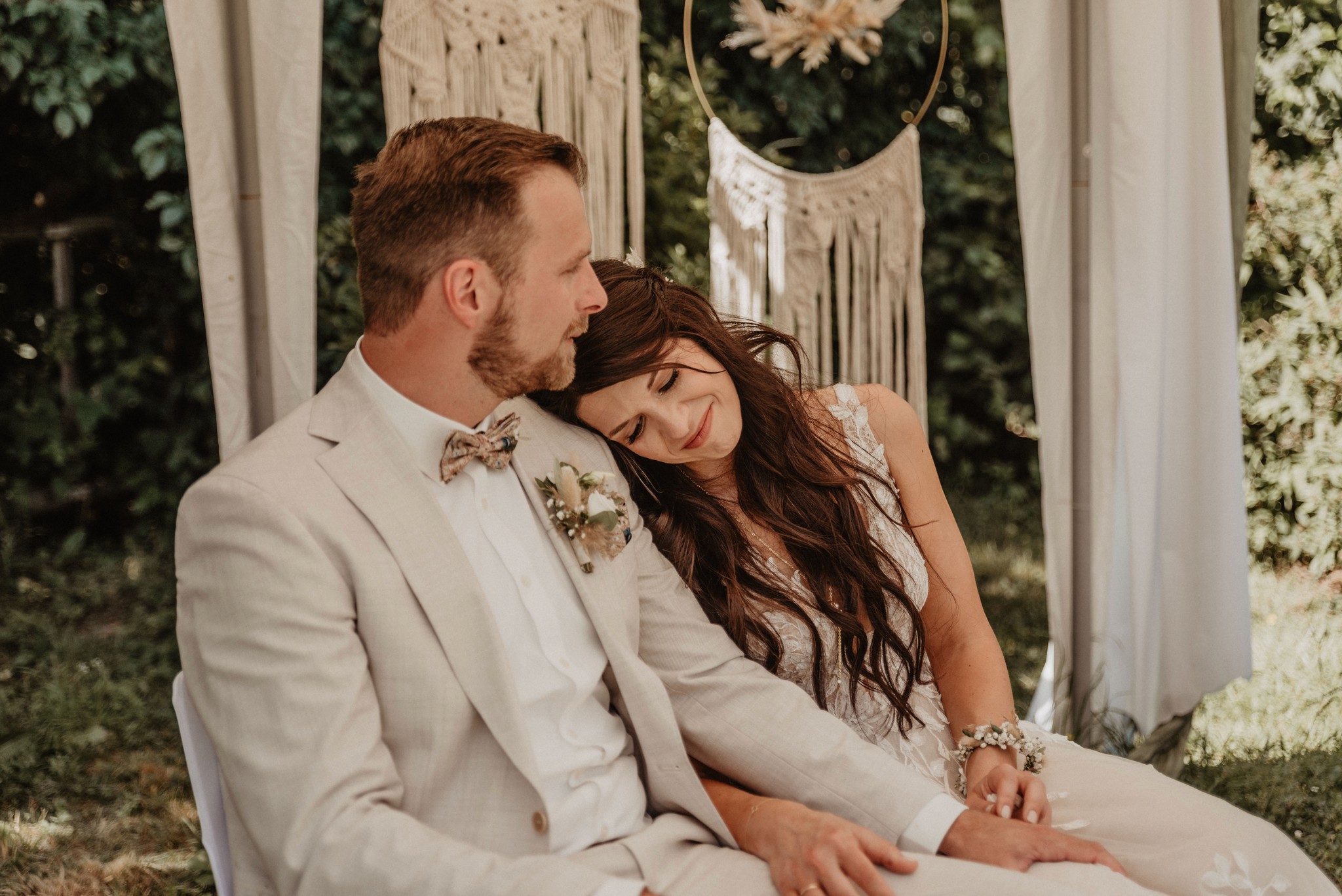 Braut und Bräutigam genießen einen ruhigen, innigen Moment im Grünen – natürliche und berührende Momentaufnahmen.