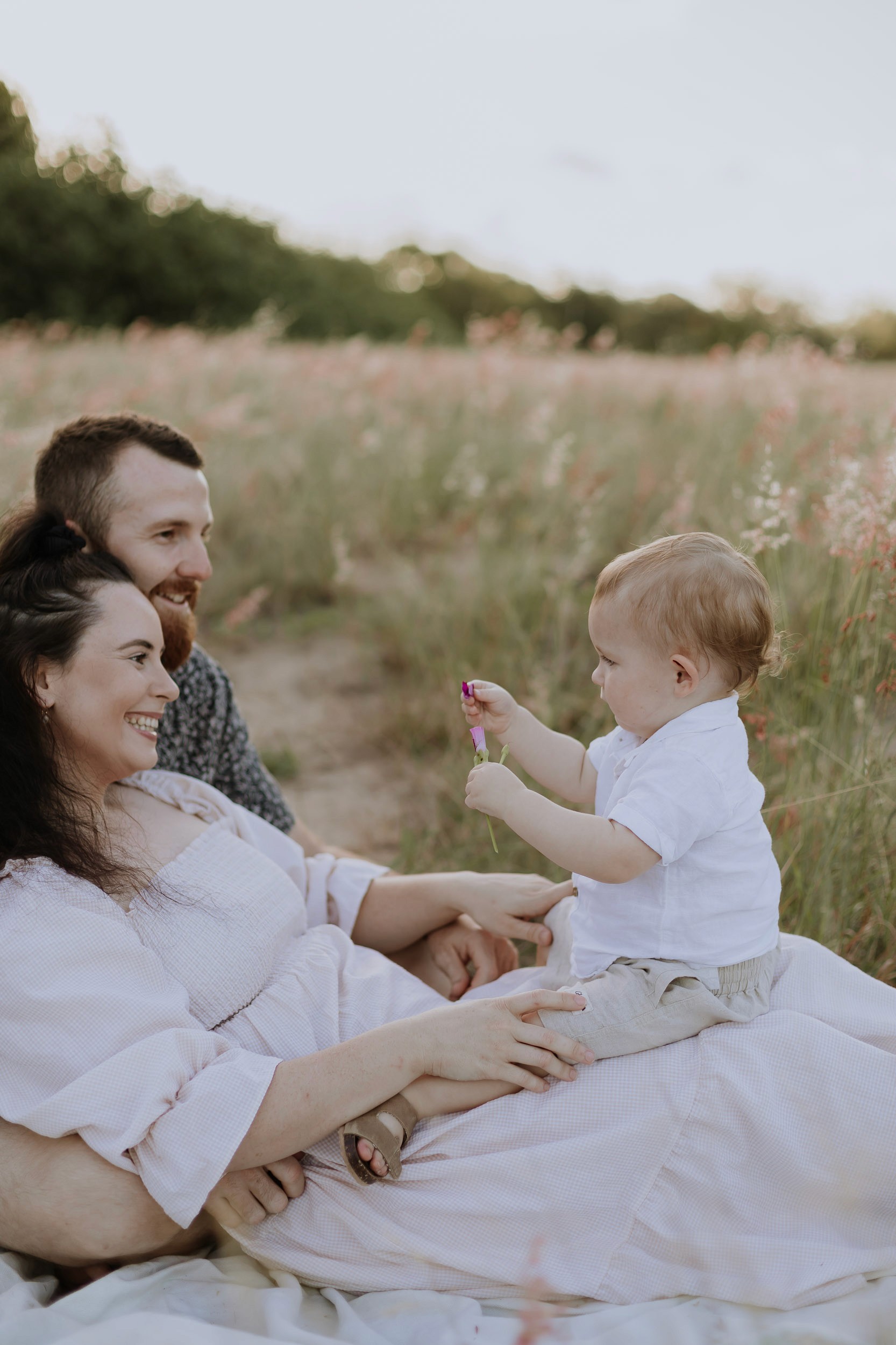 Mother and Father with child in the grass in Mackay photoshoot